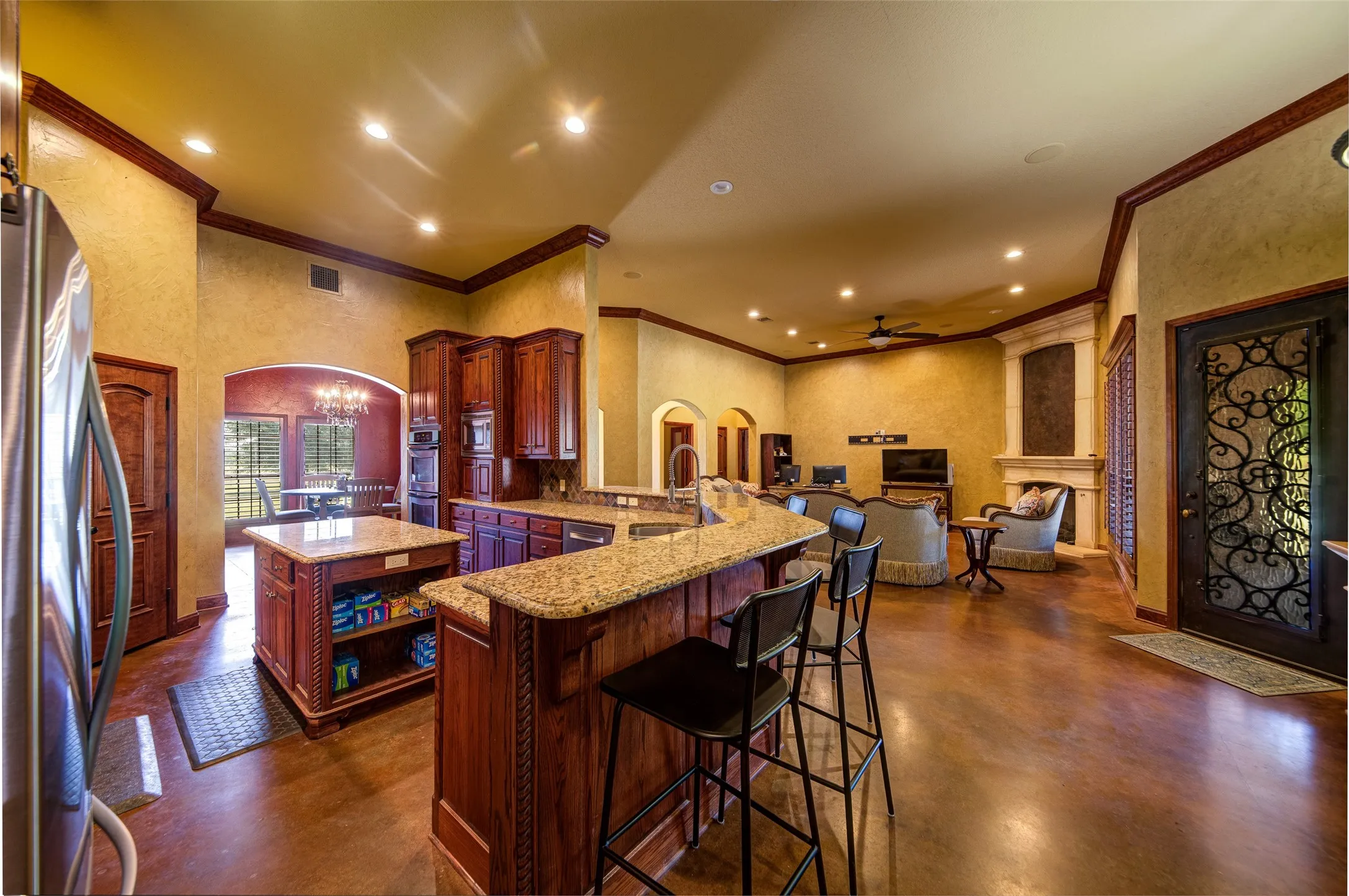 Kitchen featuring extensive wood cabinetry, granite countertops, built-in stainless steel microwave, stainless steel dishwasher, and a diamond-patterned backsplash