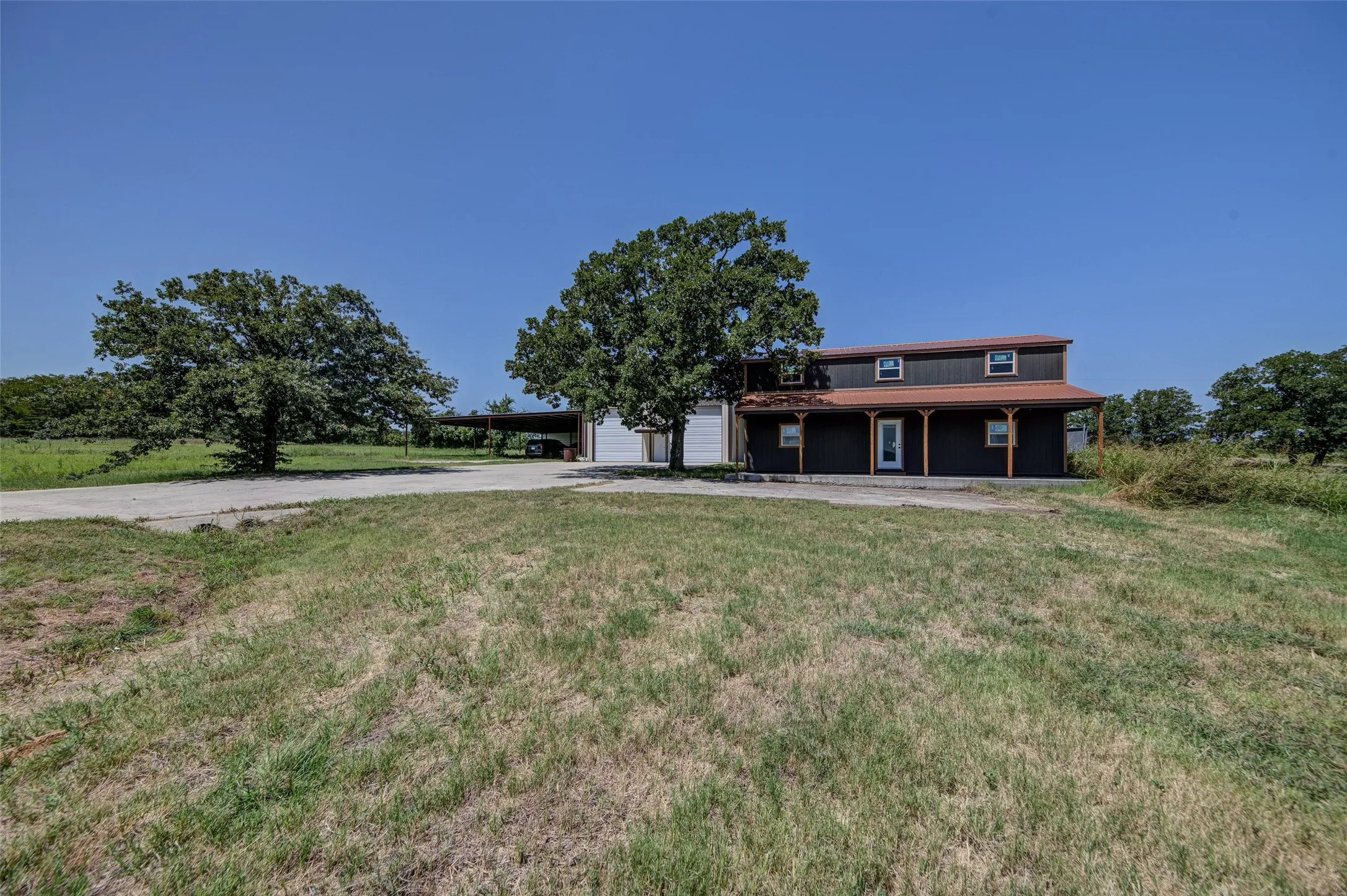 Workshop with electricity, covered RV/tractor parking, and a two-story unfinished storage building for added flexibility.