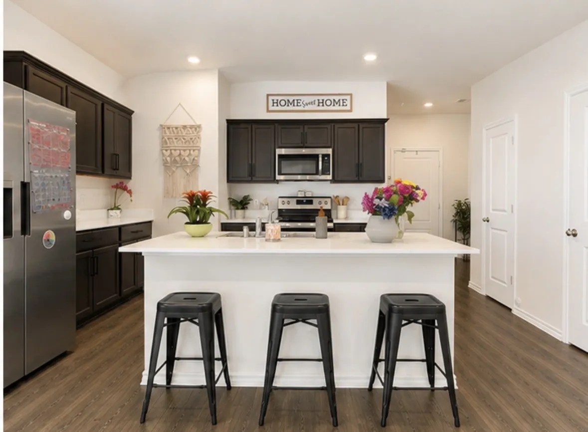Kitchen featuring a large island with seating, dark cabinetry, stainless steel appliances, white countertops, and wood-finish flooring