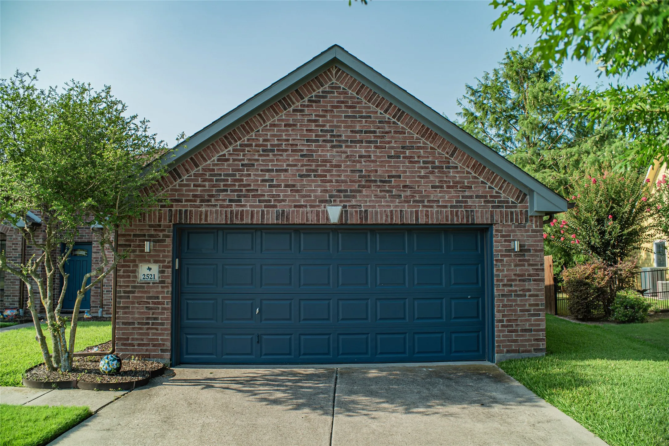 Brick facade garage with a dark blue paneled door
