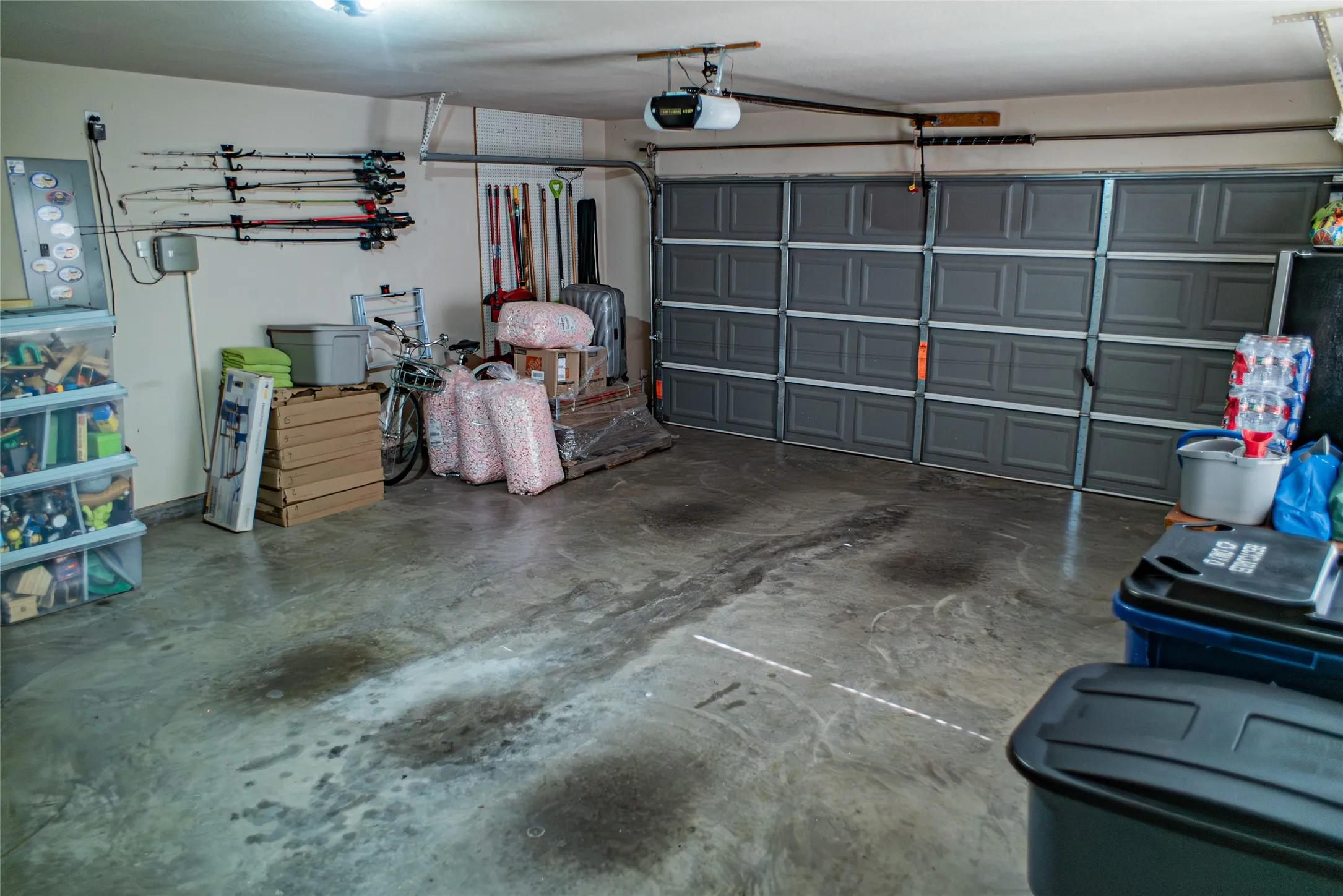Two-car garage featuring a paneled garage door and concrete flooring
