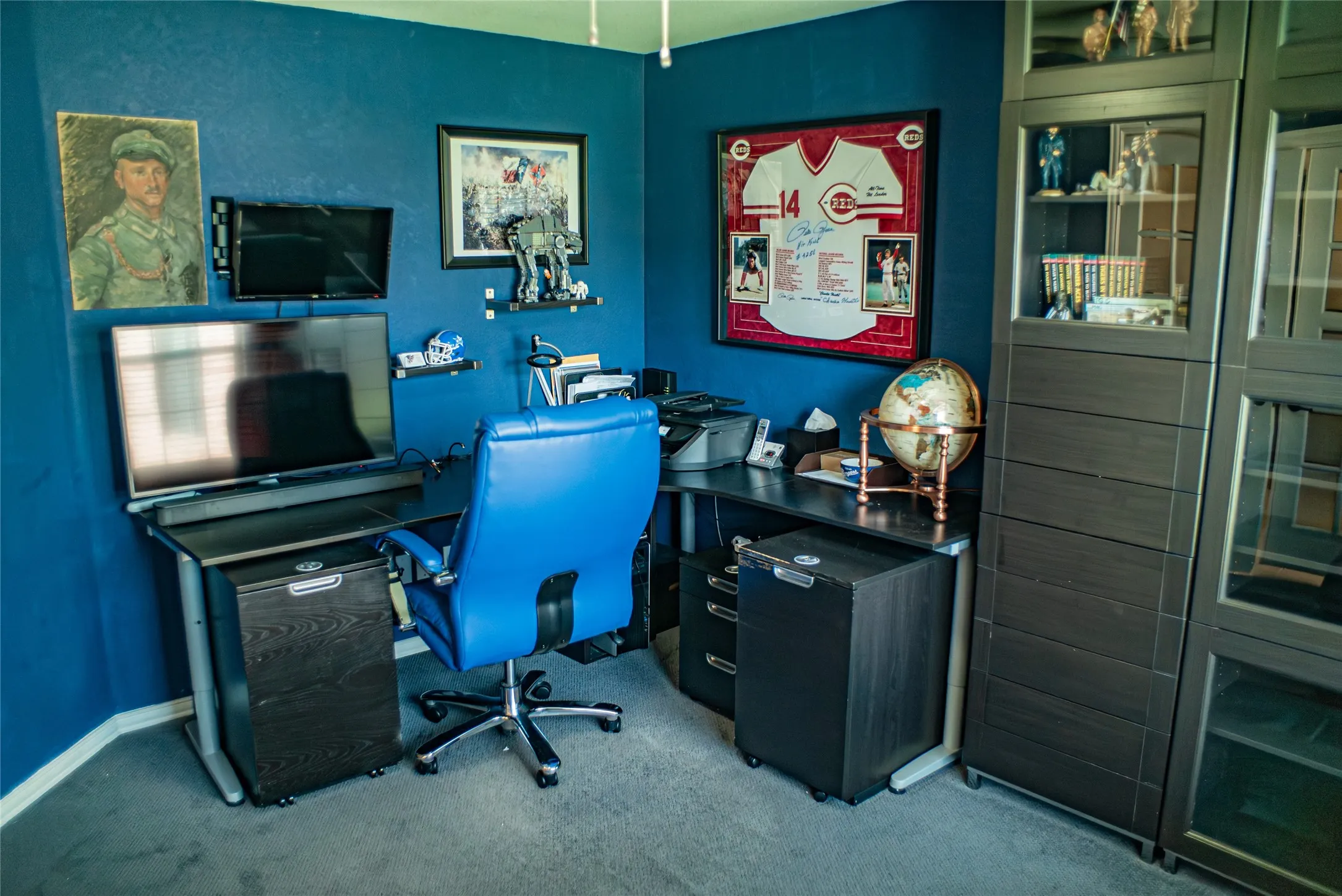 Dedicated office space featuring wall-mounted shelving and dark wood-finish cabinetry