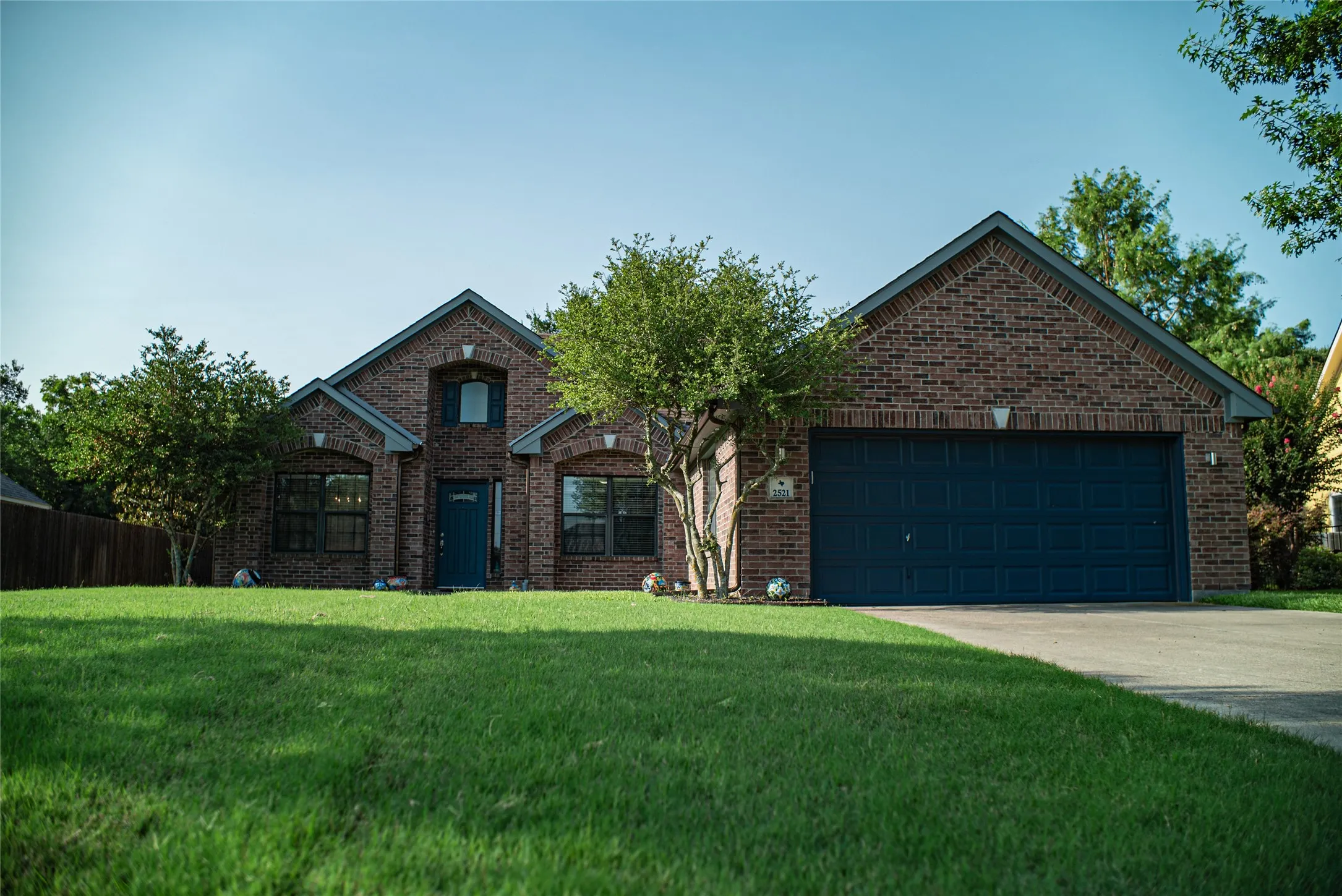 Brick exterior with a dark blue front door and garage door