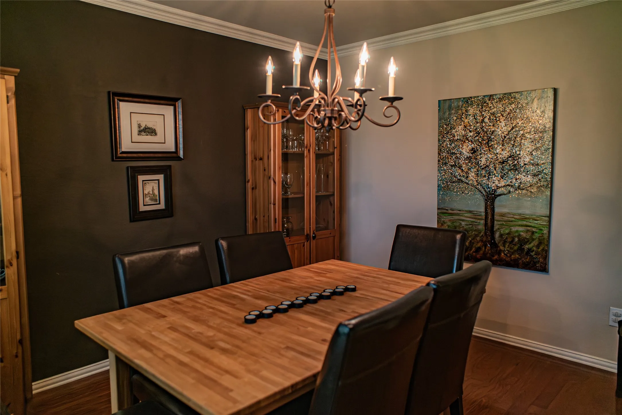 Dining area featuring a wrought iron chandelier, wood-finish flooring, and crown molding