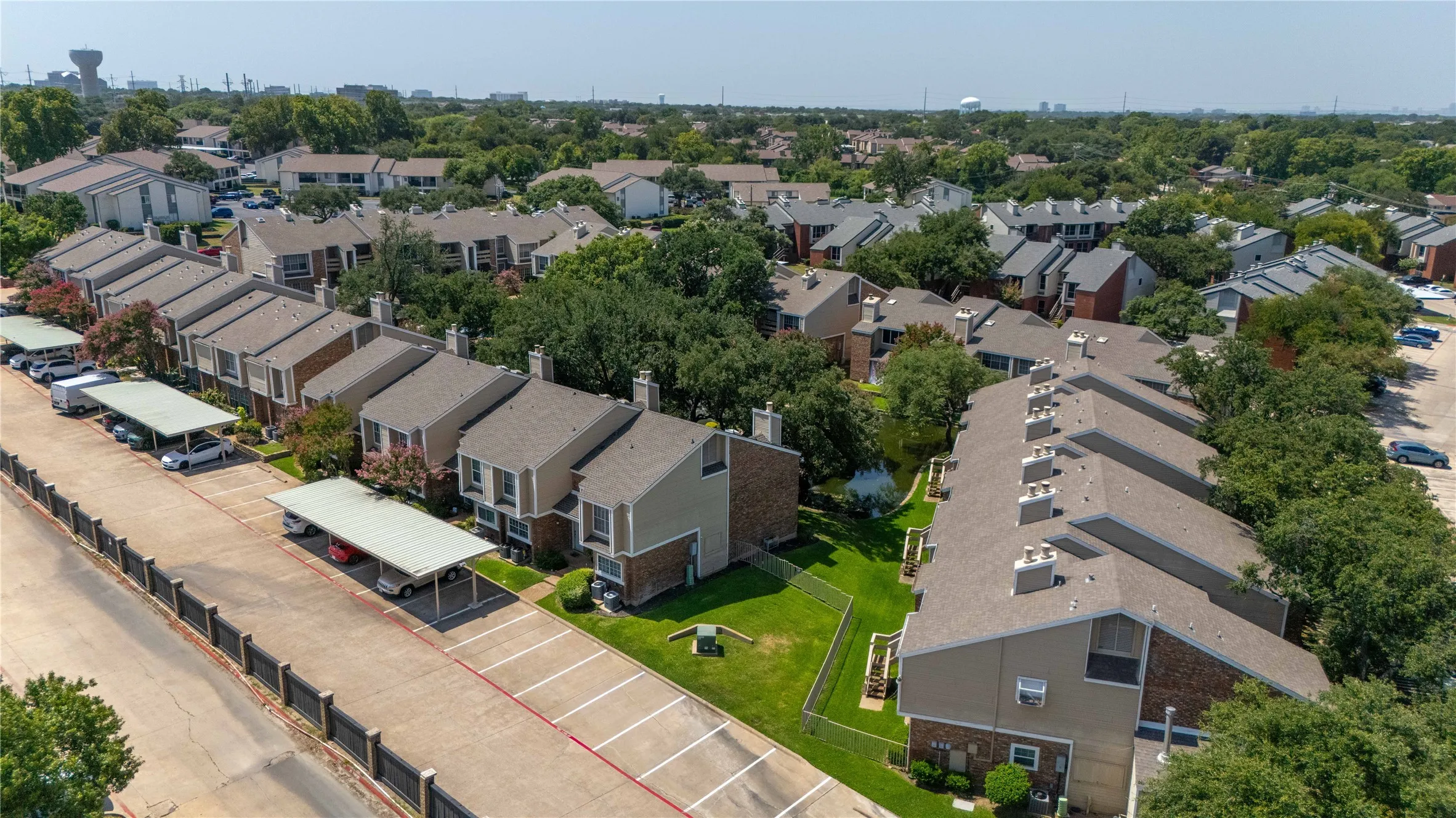 Aerial perspective showcasing a community of multi-story townhomes with pitched roofs and individual backyards