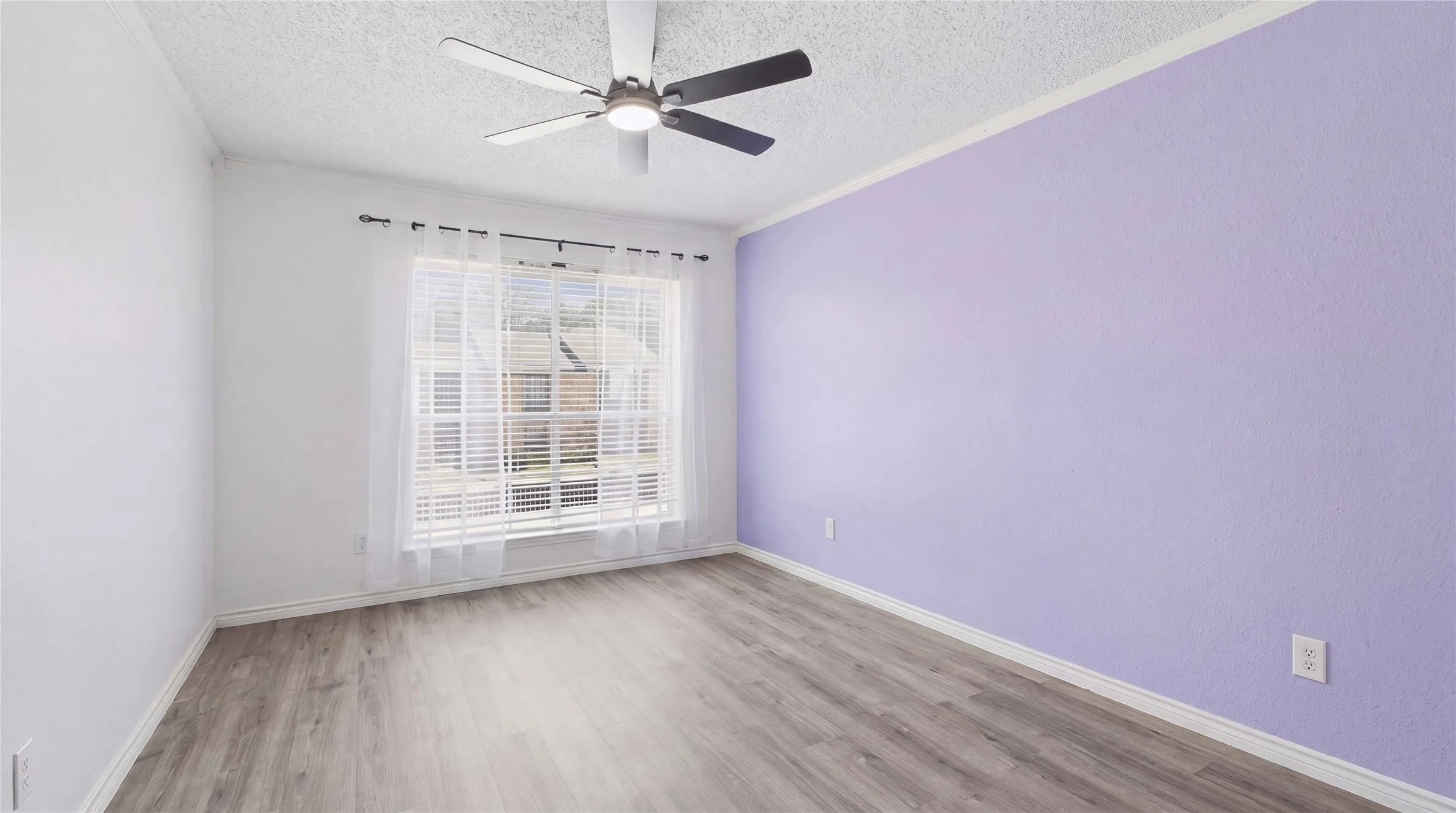 Light-toned wood-finish flooring, ceiling fan with light fixture, window with blinds, and white​​‌​​​​‌​​‌‌​‌‌​​​‌‌​‌​‌​‌​​​‌​​ trim