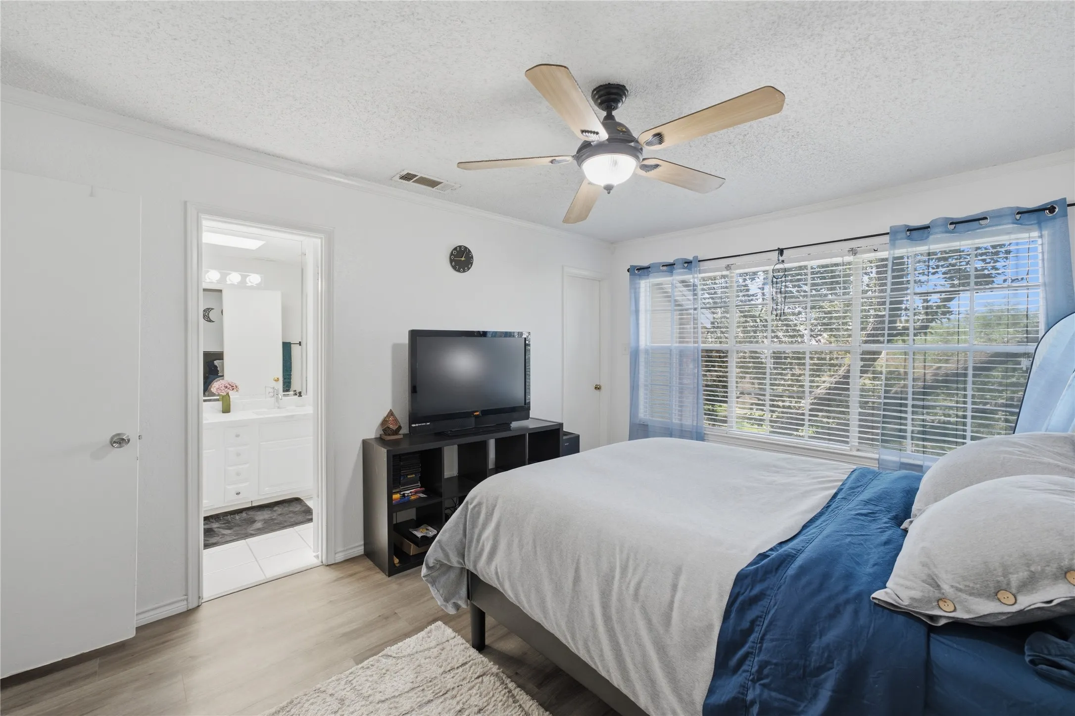 Spacious room with wood-finish flooring and a ceiling fan with integrated lighting