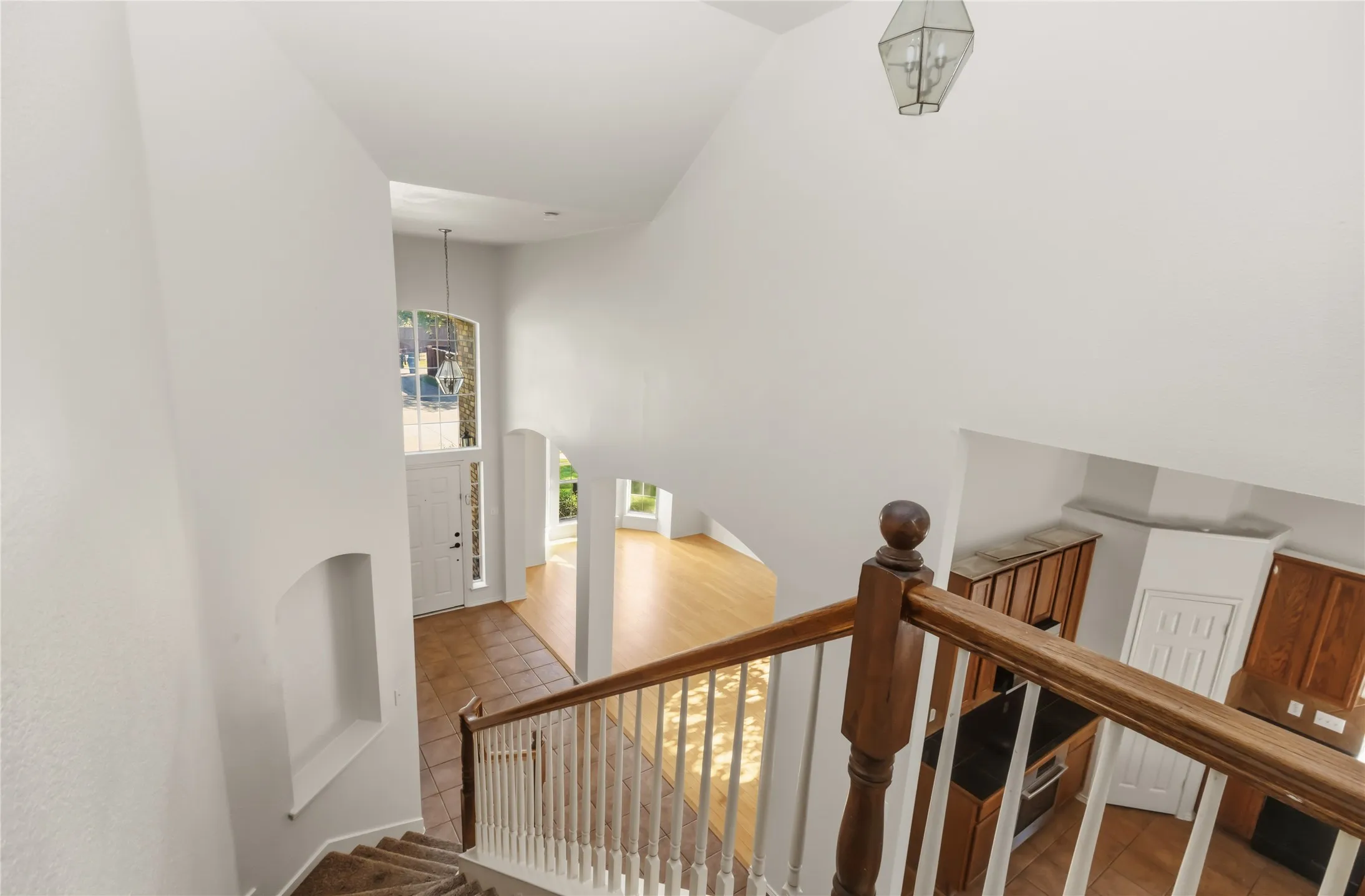 Two-story foyer with a transom window and sidelights, tile flooring, and a decorative niche