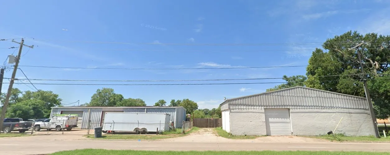 Two industrial-style buildings featuring roll-up doors, metal siding, and a gravel driveway