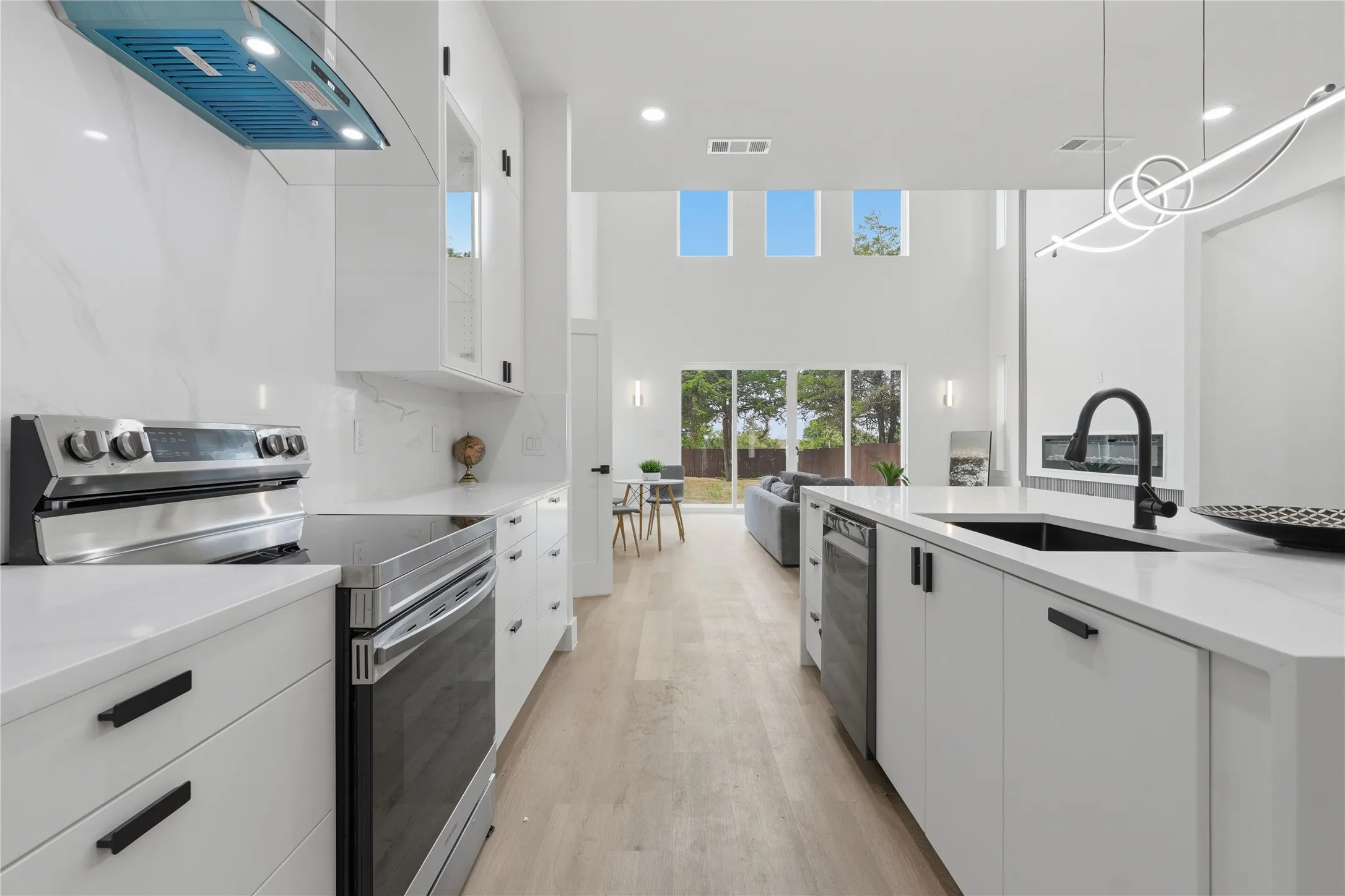 Open-concept living space with high ceilings and light wood-finish flooring
