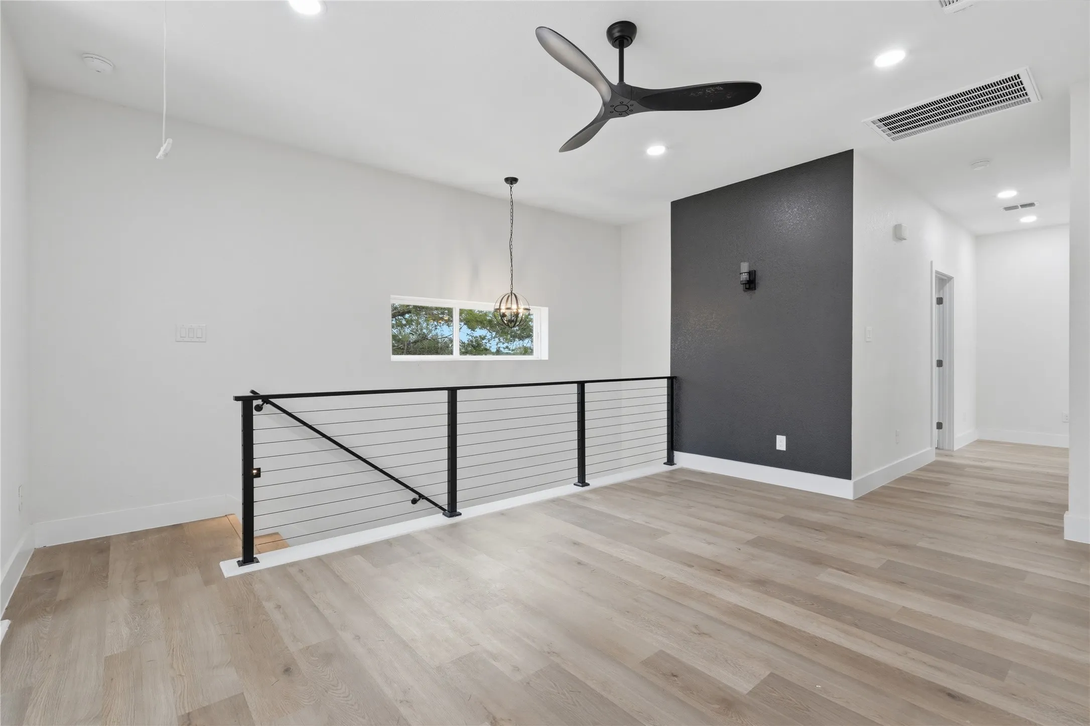 Loft area featuring wood-finish flooring, a contemporary ceiling fan, recessed lighting, and a cable railing system