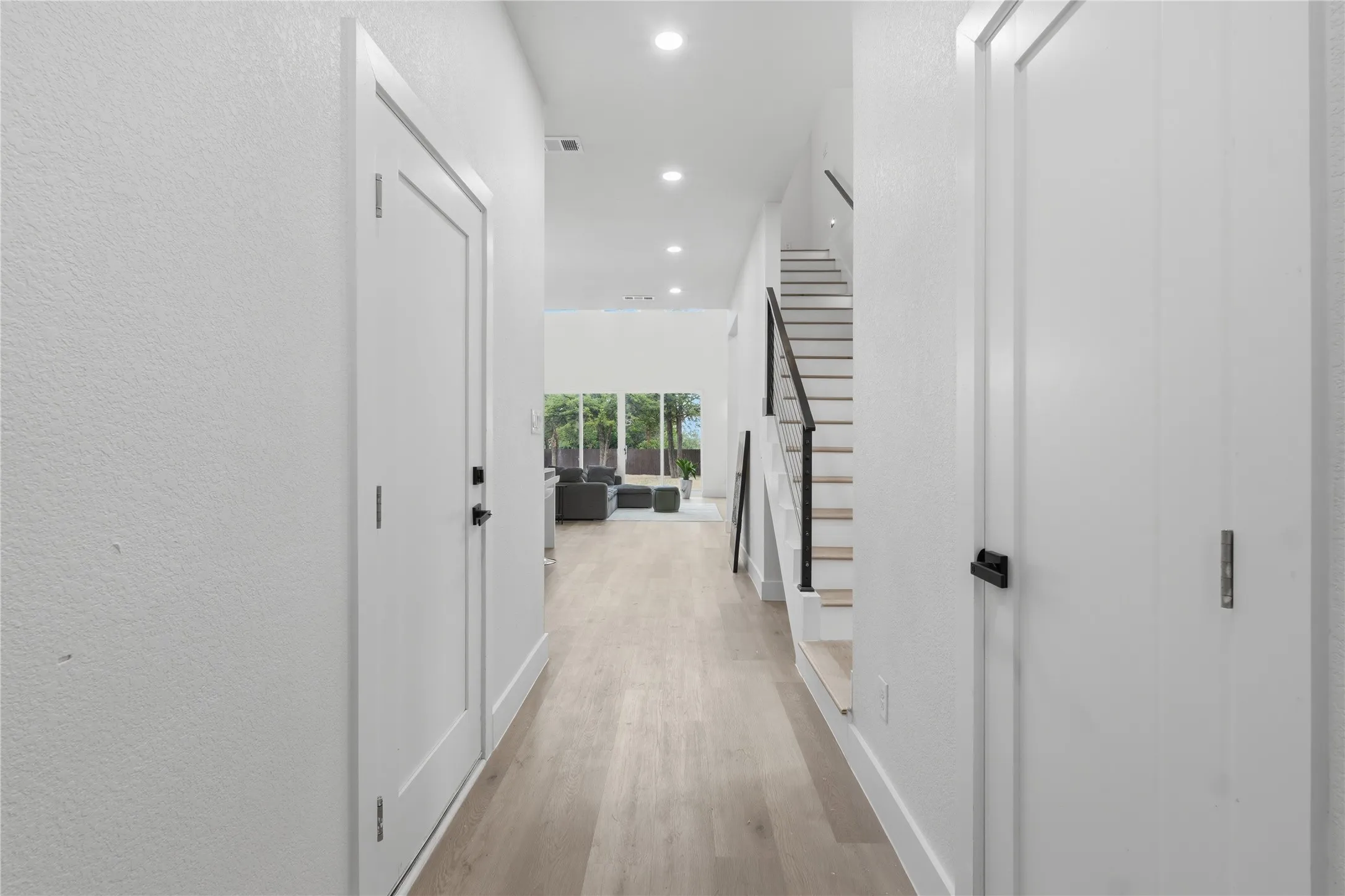 Light wood-finish flooring extending through the hallway