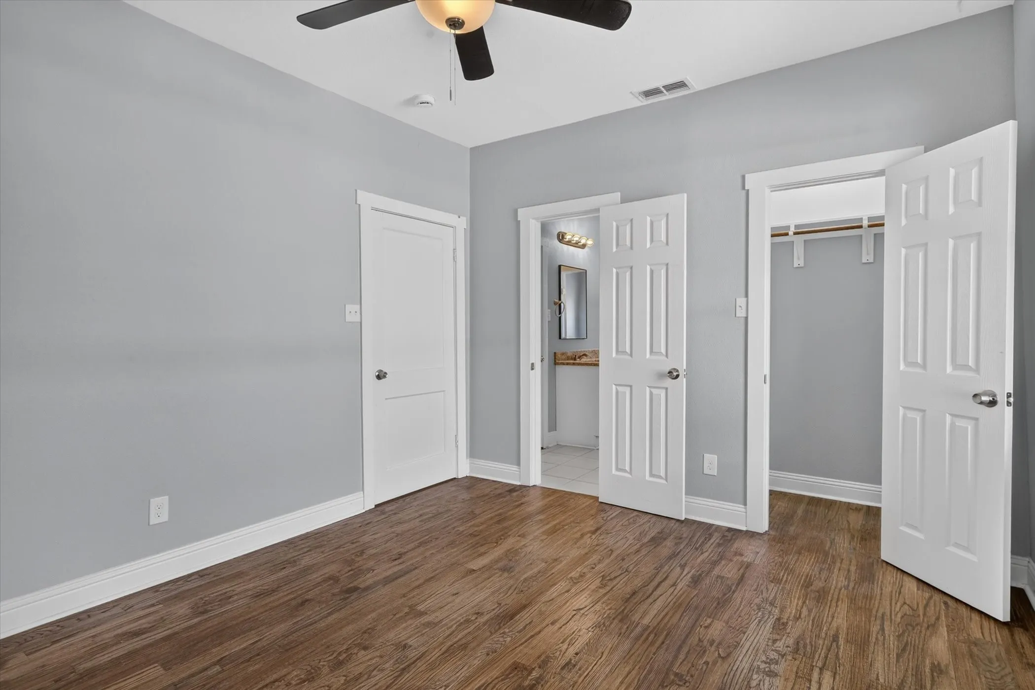 Interior room featuring wood-finish flooring, light gray walls, and white trim