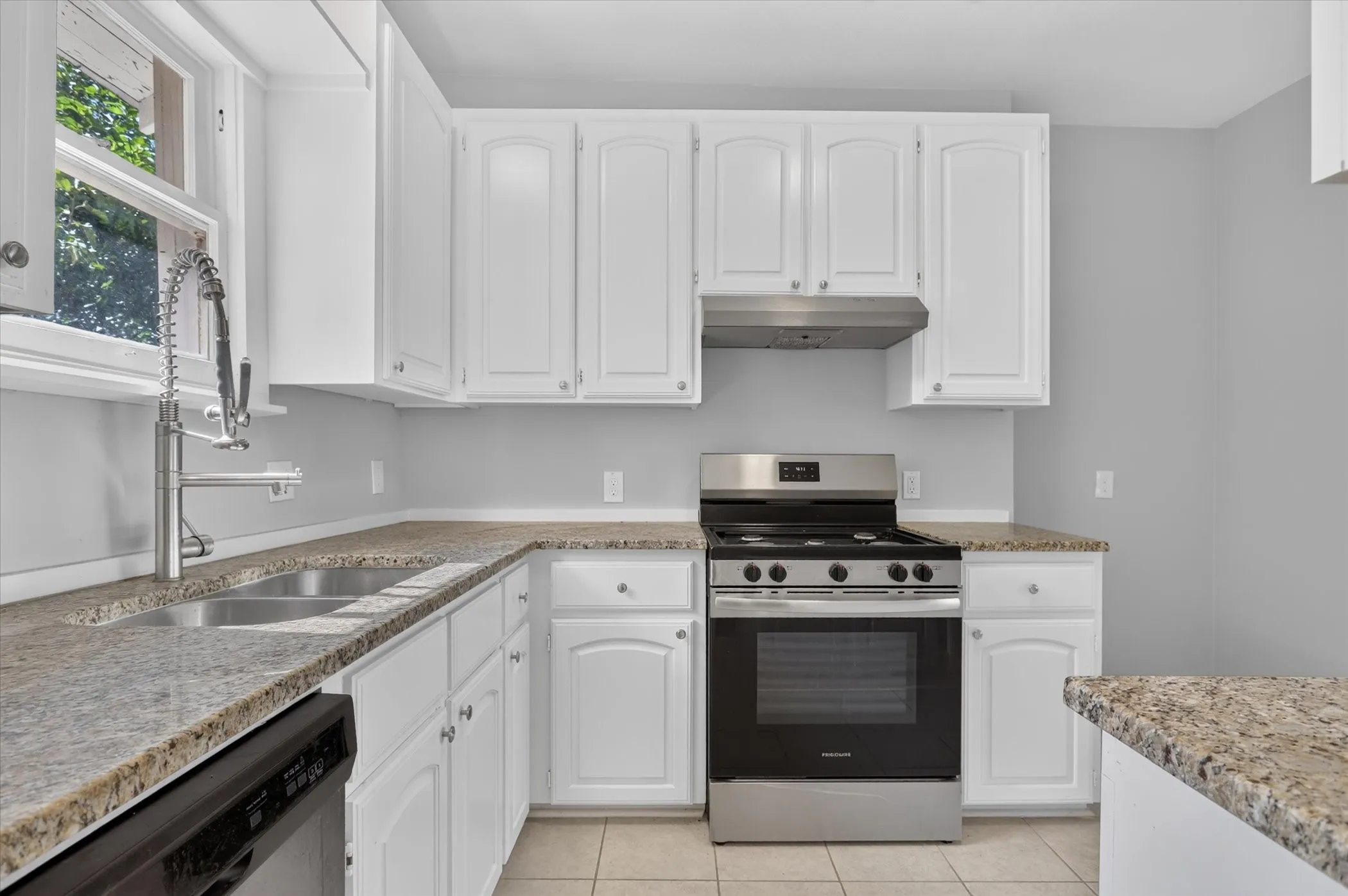 Kitchen featuring white cabinetry, stone-finish countertops, stainless steel appliances, and tile flooring