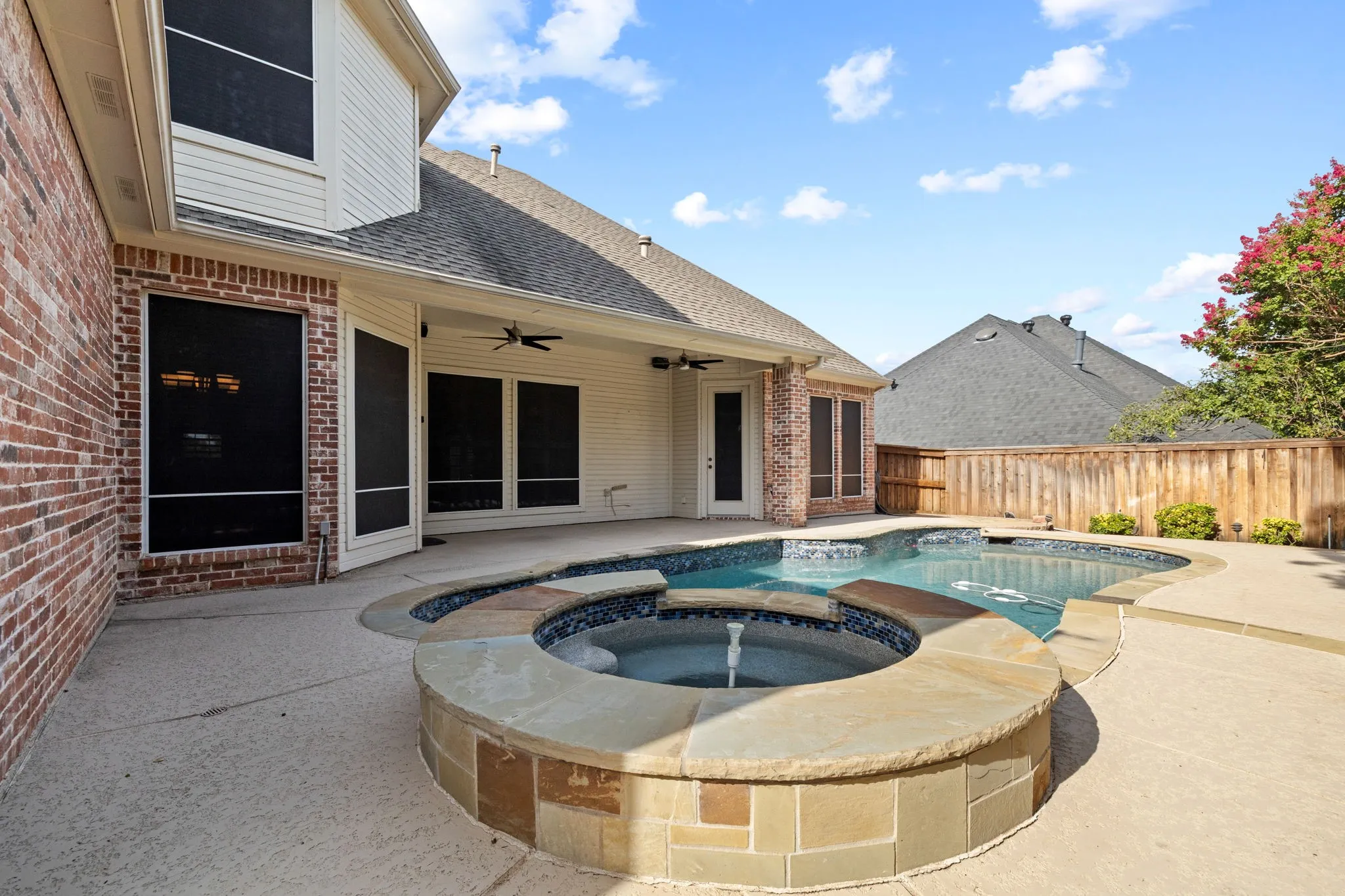 Custom freeform pool with integrated spa and stone coping