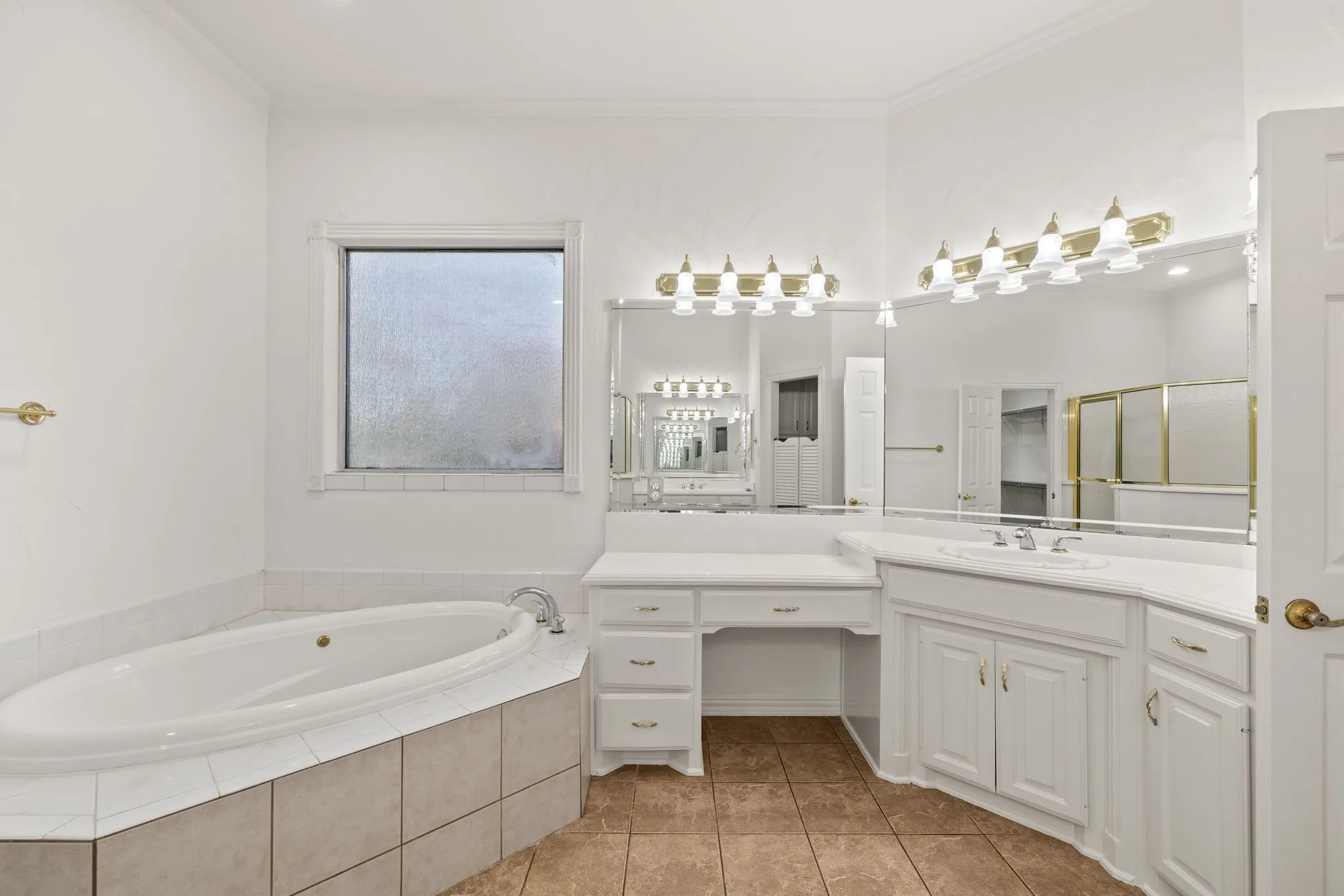 Recessed oval tub with tile surround, paired with a dedicated vanity station featuring ample storage