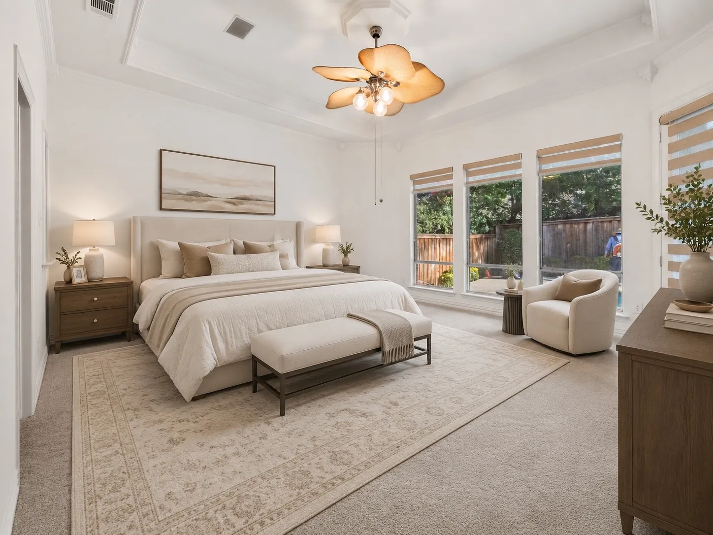 Spacious room featuring a tray ceiling with a ceiling fan, plush carpeting, large windows with blinds, and a built-in wall-mounted speaker