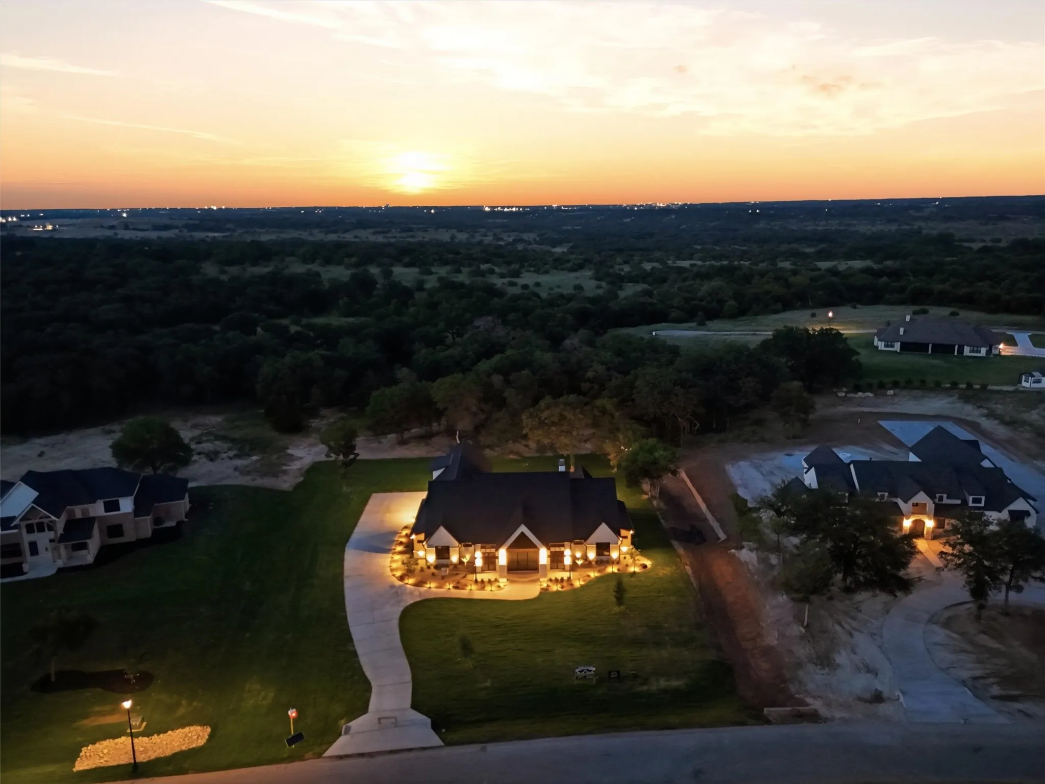 Aerial view of this gorgeous estate at night, with exterior lighting.