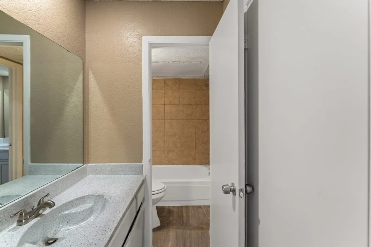 Vanity featuring a speckled countertop with an integrated sink and brushed nickel faucet