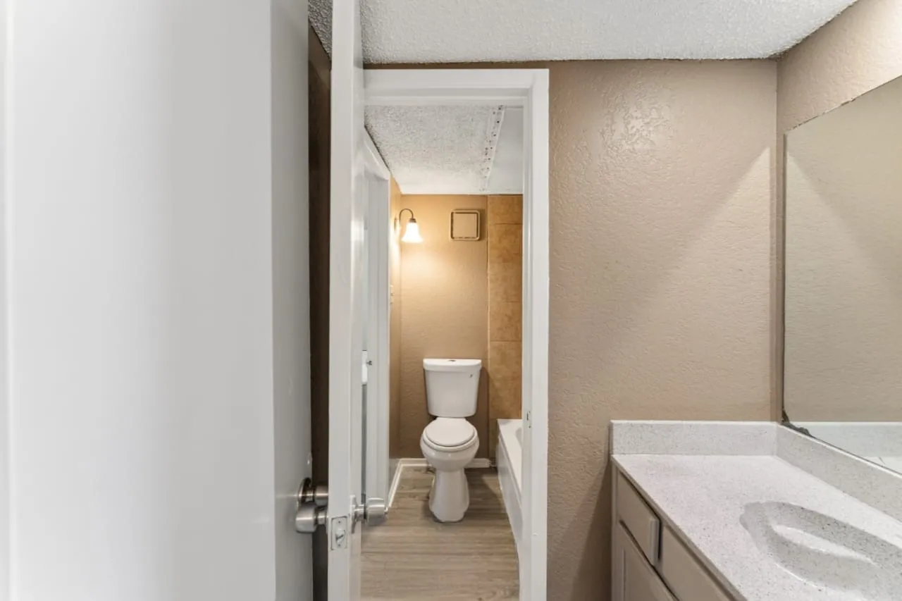 Bathroom vanity featuring a light-colored countertop with an integrated sink and a wall-mounted mirror