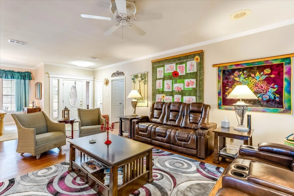 Living area featuring wood-finish flooring and a ceiling fan