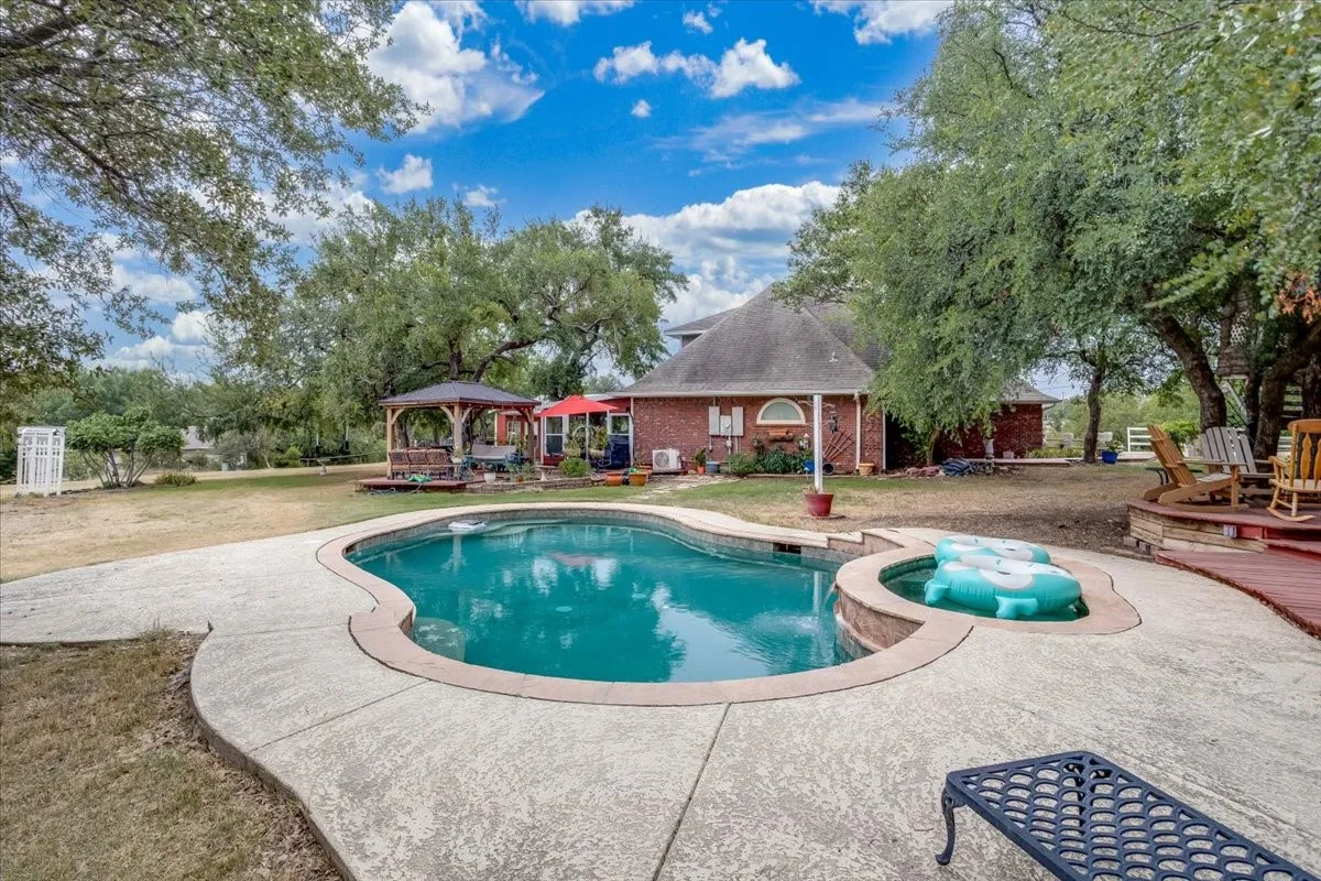 Resort-style pool with integrated spa and concrete decking