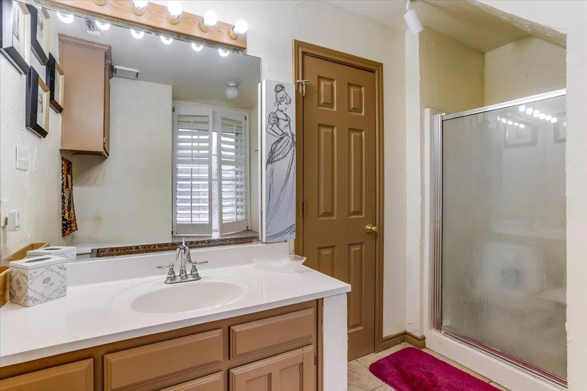 Bathroom vanity featuring a single basin, a chrome faucet, and wood-finish cabinetry