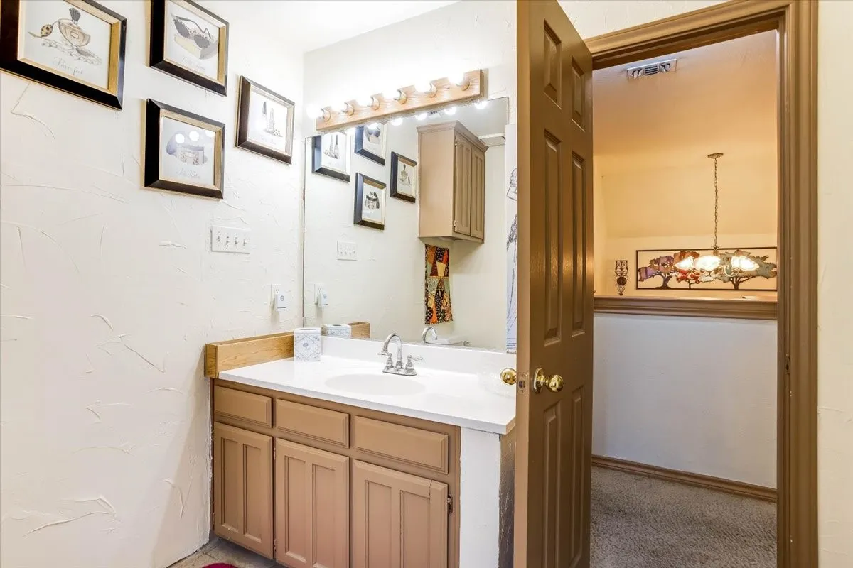 Bathroom vanity with a white countertop and wood-finish cabinetry