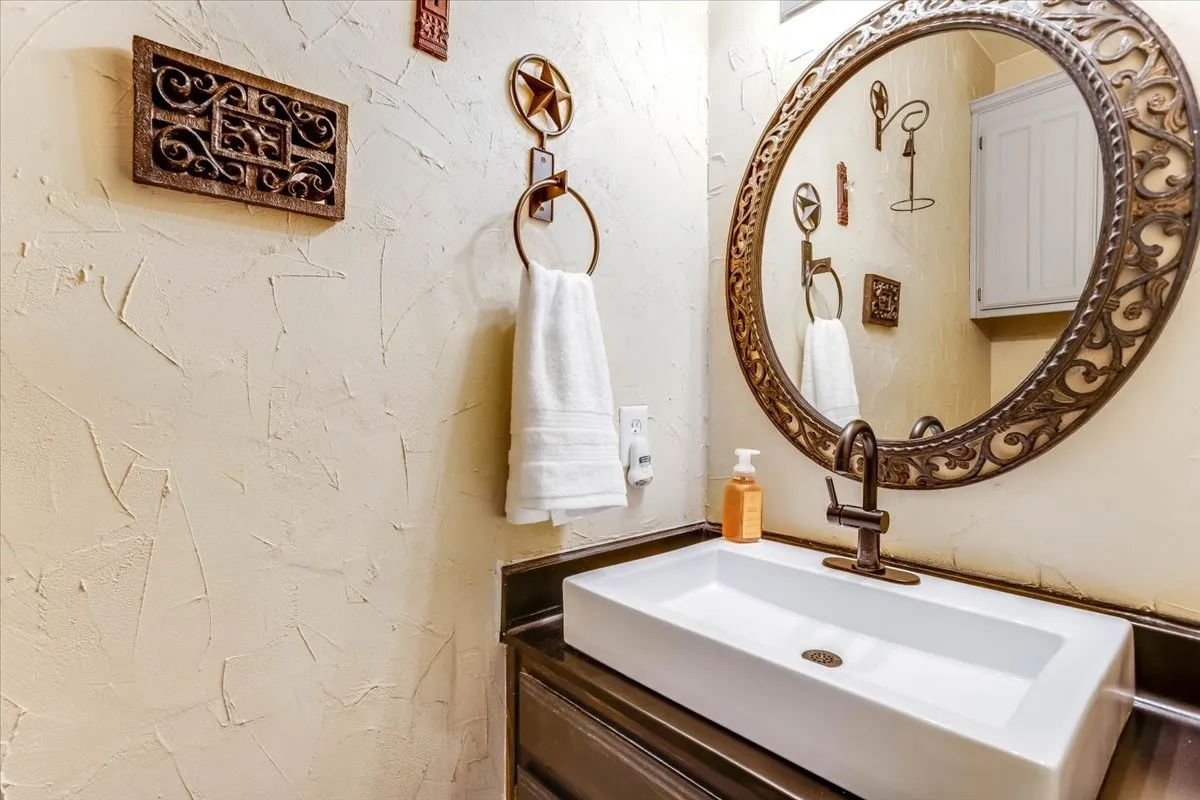 Rectangular vessel sink with bronze-finish faucet, set on a dark countertop