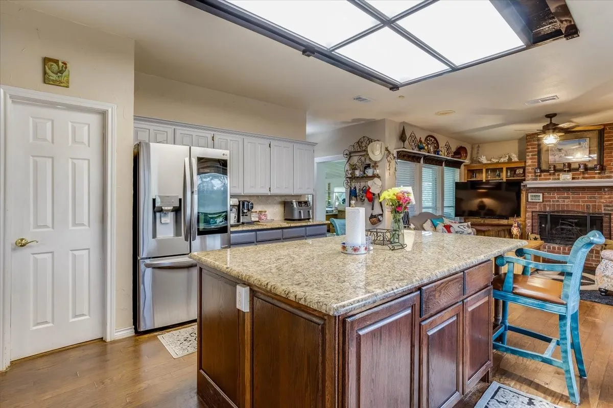 Spacious kitchen island with granite countertop and wood cabinetry