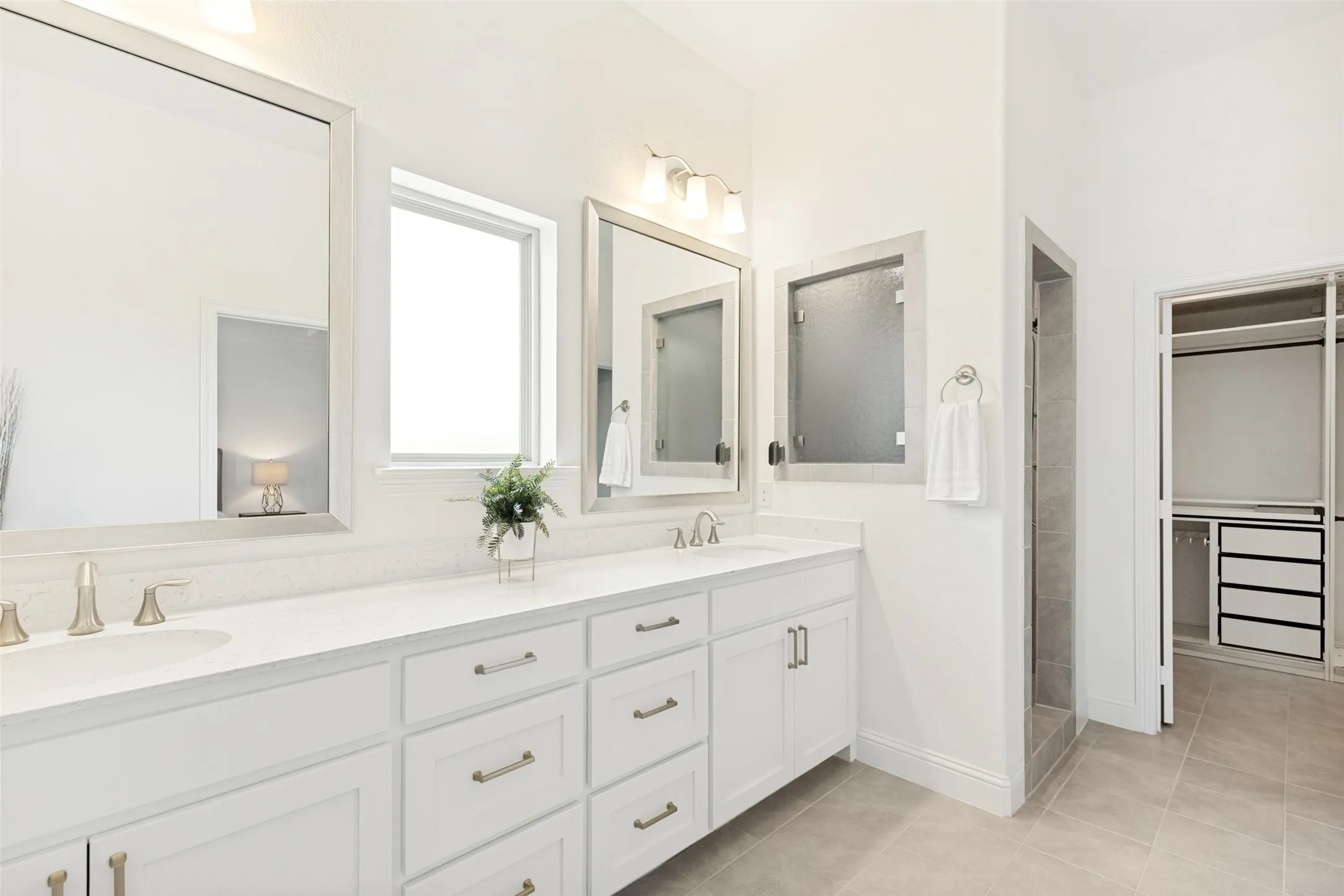 Spacious bathroom featuring a dual vanity with white cabinetry and light-toned countertops
