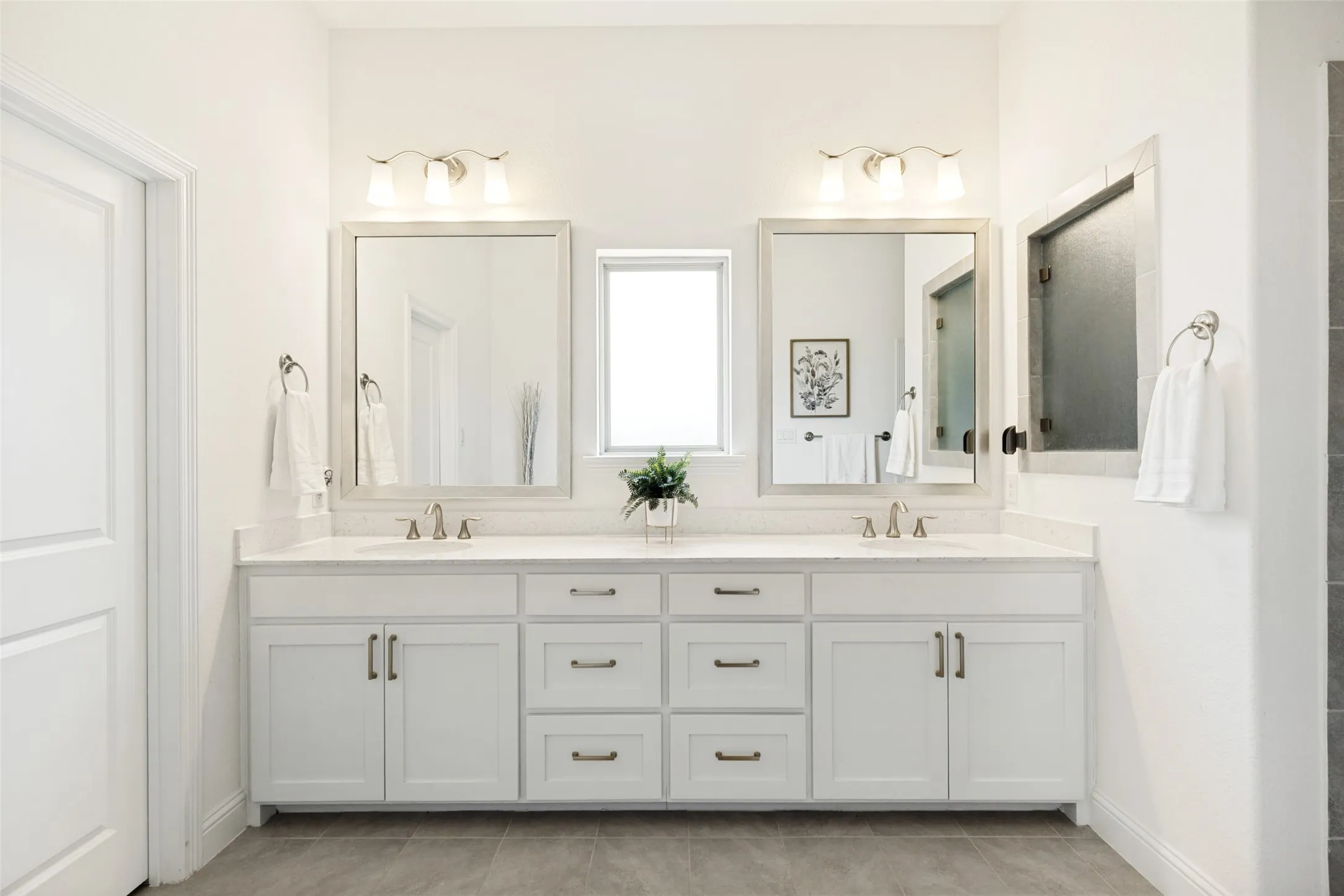 Double vanity featuring white shaker cabinetry, light-toned countertops, and brushed nickel hardware