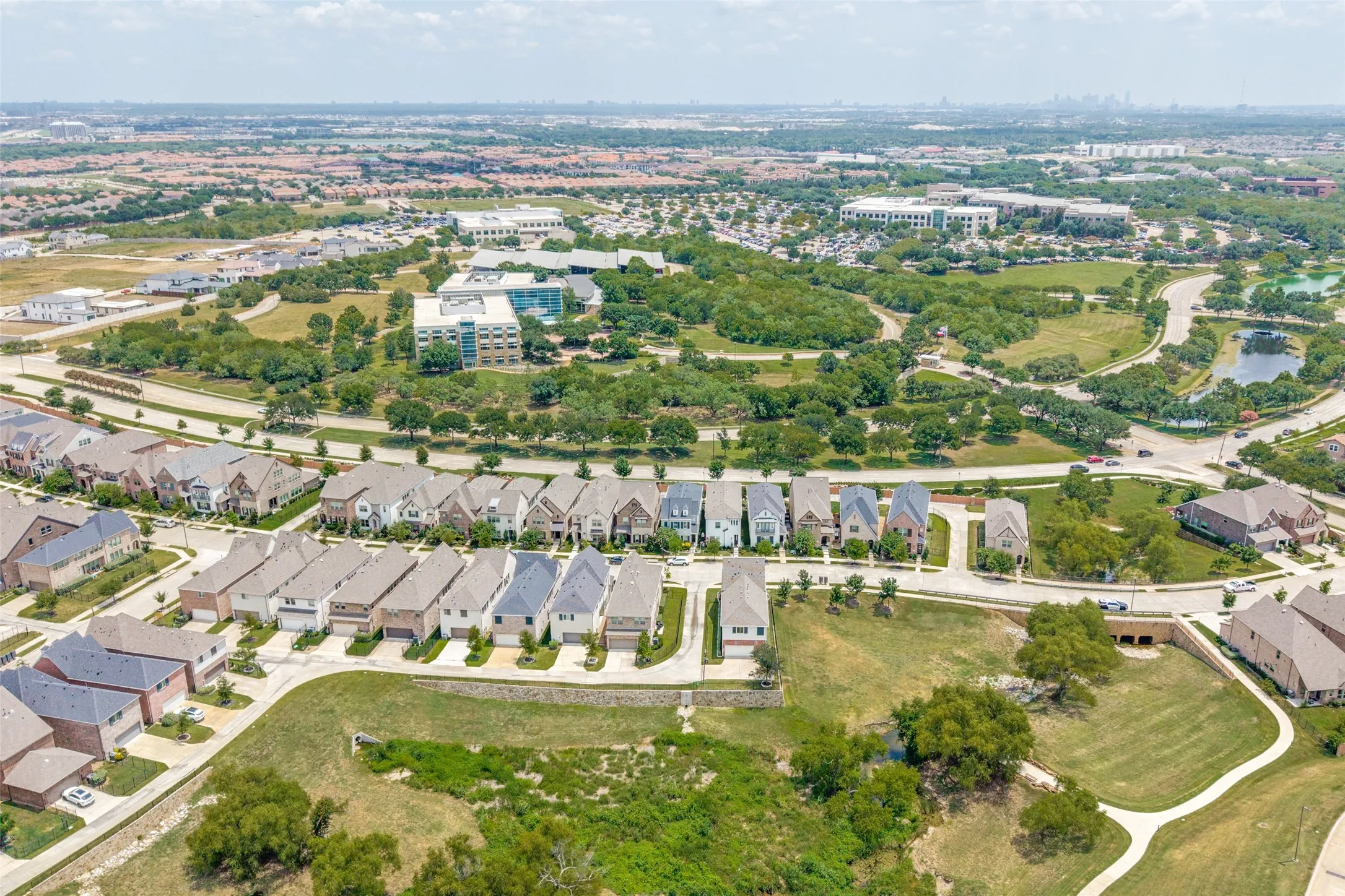 Aerial perspective showcasing a residential area with diverse architectural styles, surrounded by green spaces and mature trees