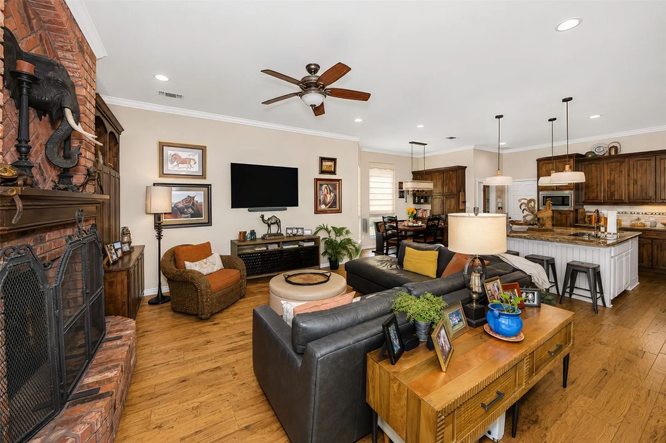 Family room features hardwood flooring and a brick fireplace with gas logs.