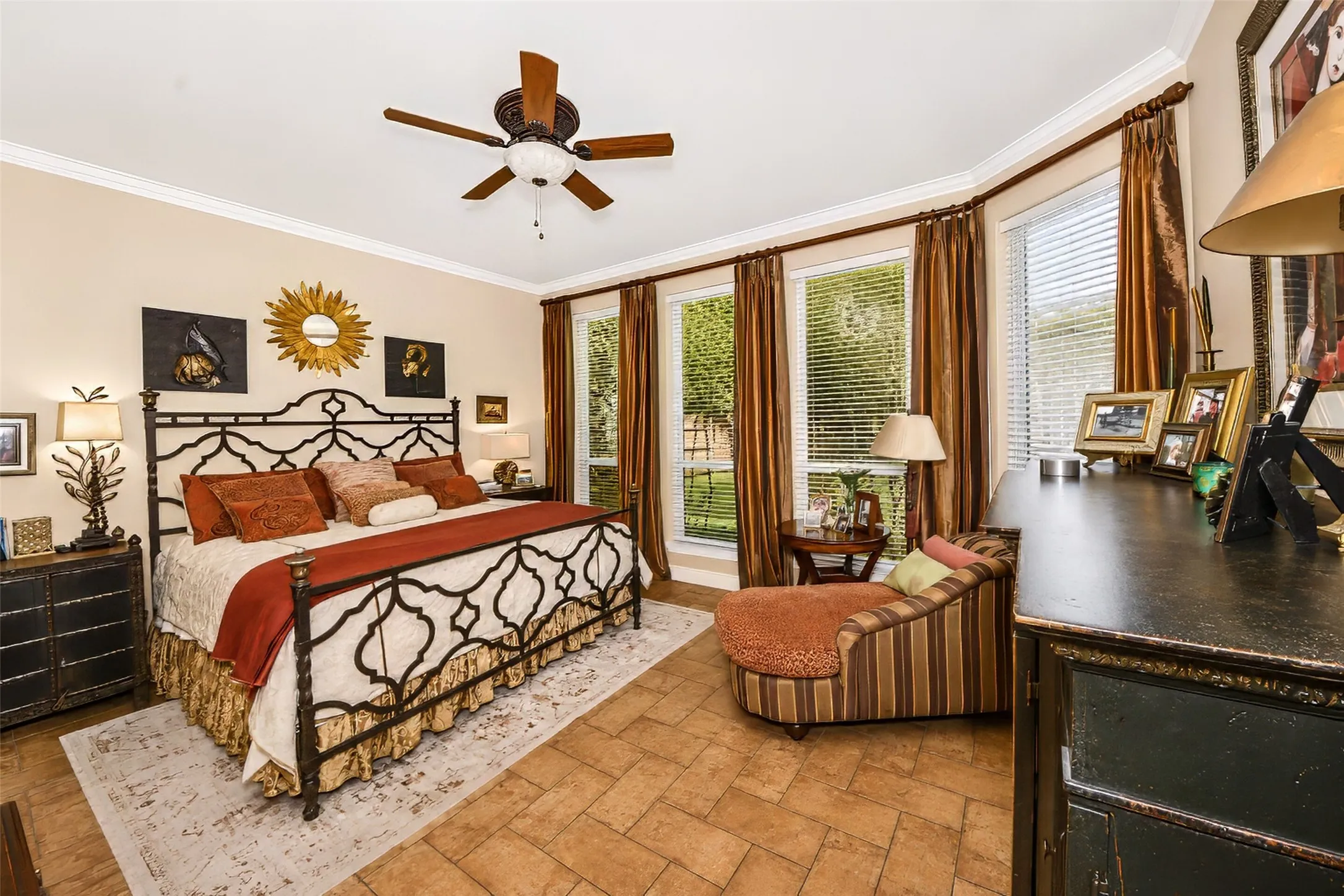 Primary bedroom features a wall of windows overlooking the back yard, graced by custom drapery.