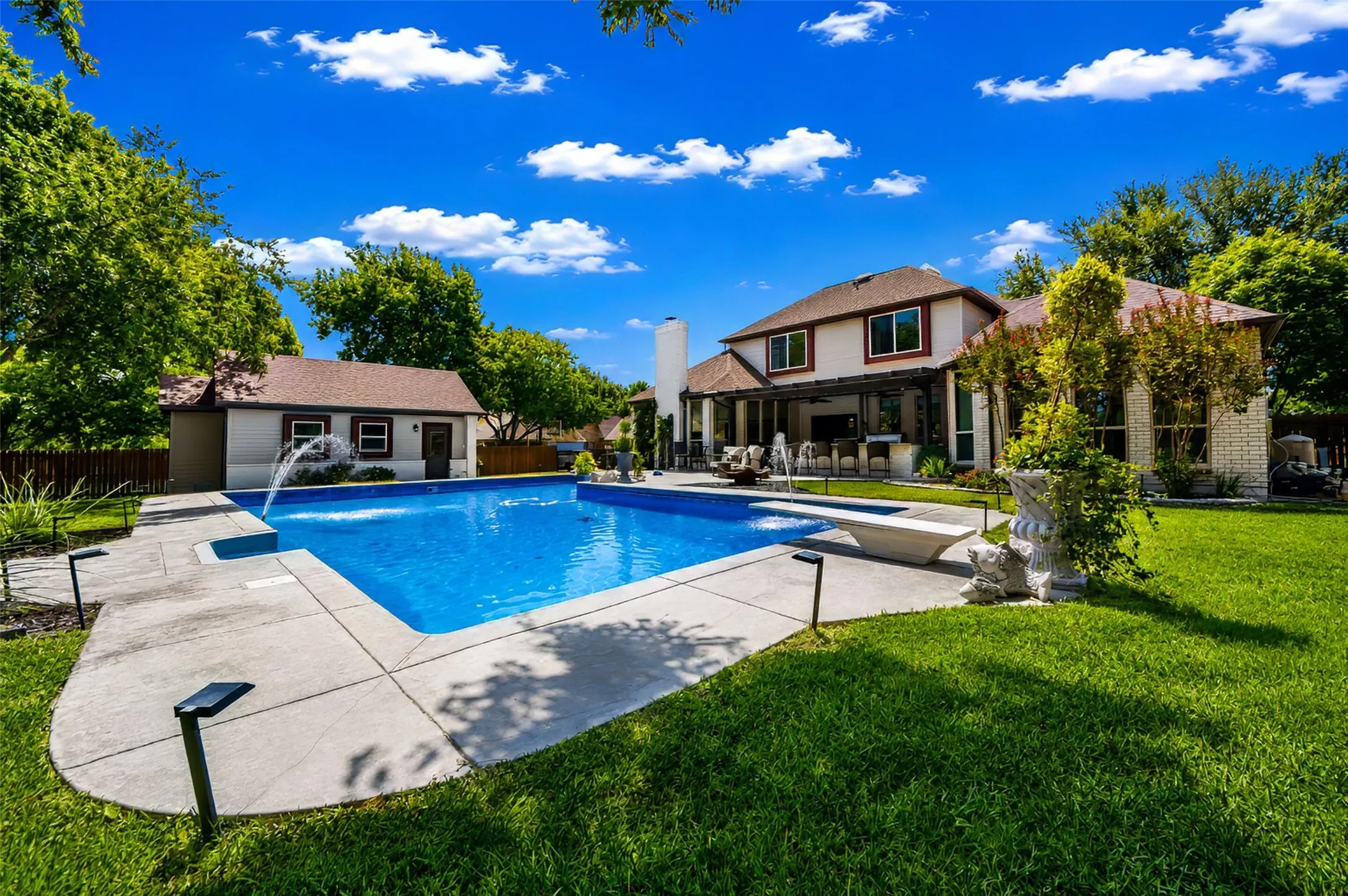 Pool looking toward back of home and detached garage.