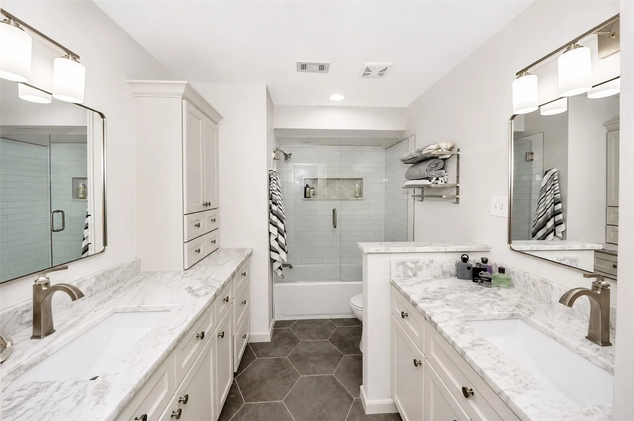 Upstairs bathroom has been newly remodeled featuring a new tub, flooring and marble counter tops with custom cabinetry.