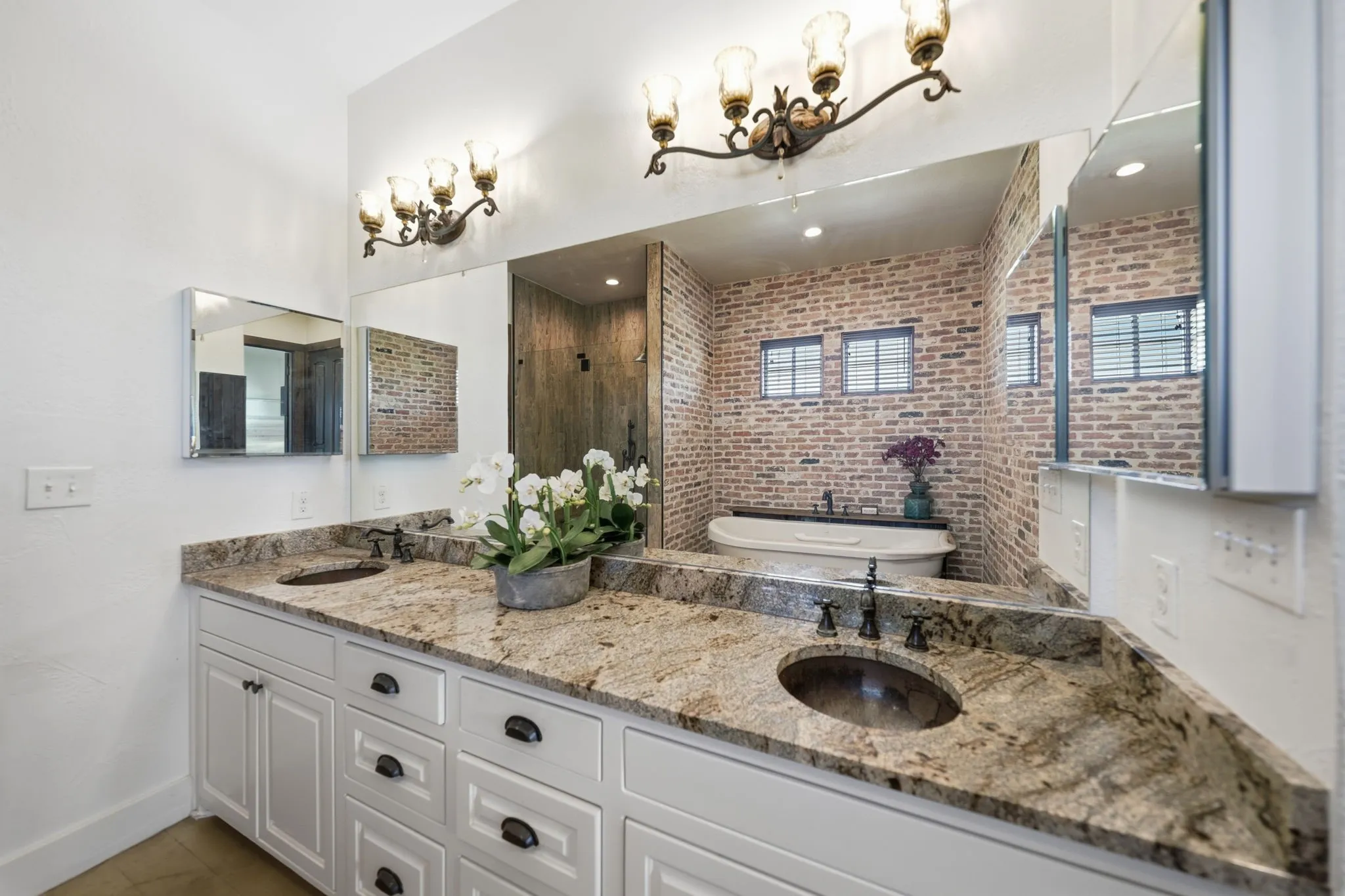 Double vanity with granite countertops and white cabinetry