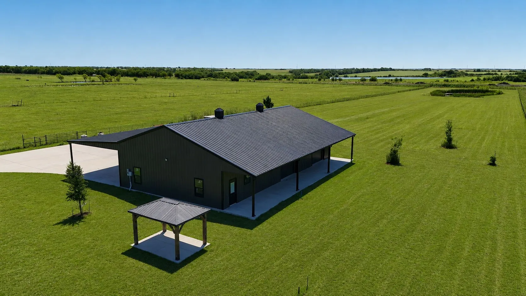 Modern dark gray metal building featuring a black metal roof