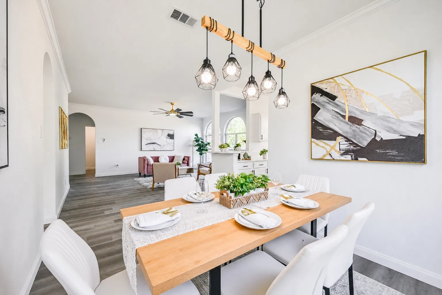Dining area featuring a contemporary linear chandelier with five geometric pendant lights