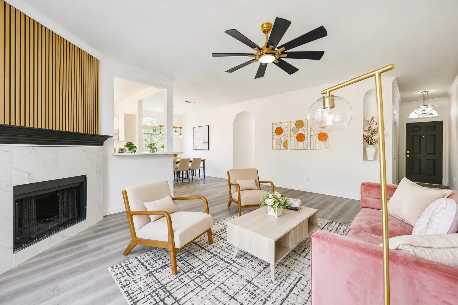Living area featuring a fireplace with a white marbled surround, a black mantle, and a vertical wood-finish accent wall