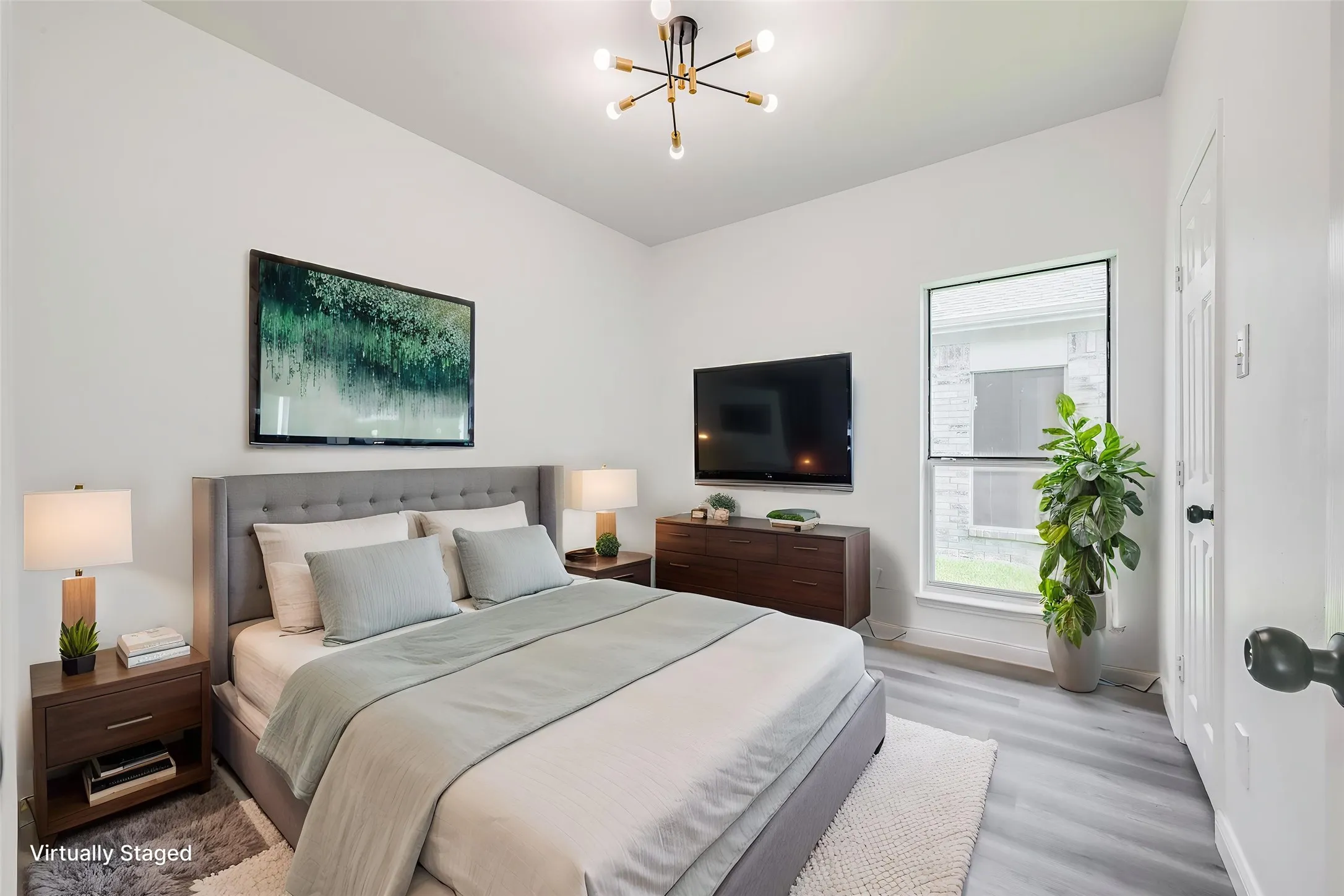 Vaulted ceiling bedroom featuring wood-finish flooring, a contemporary sputnik light fixture, and a single-pane window