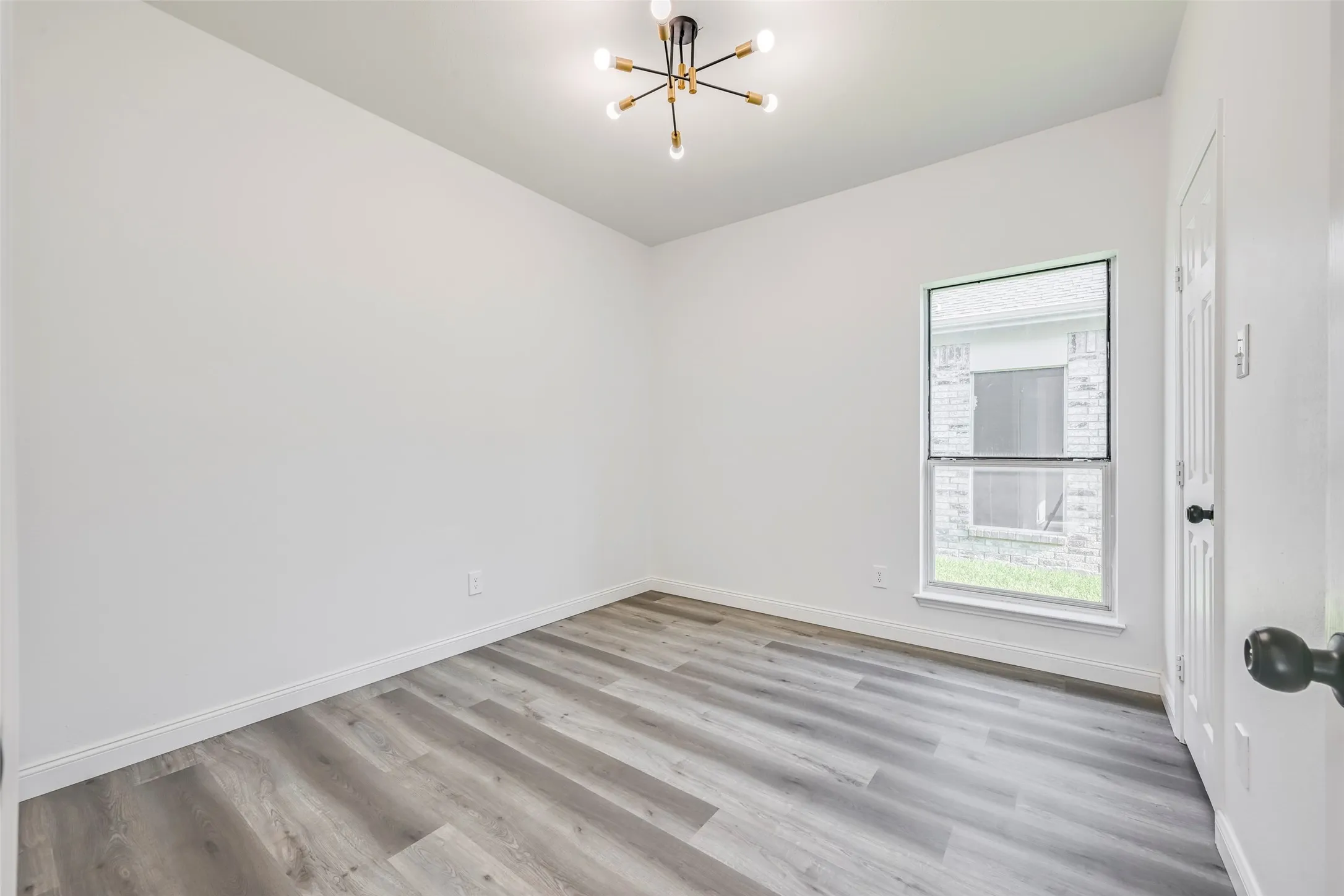Room featuring wood-finish flooring and a contemporary sputnik-style ceiling light fixture