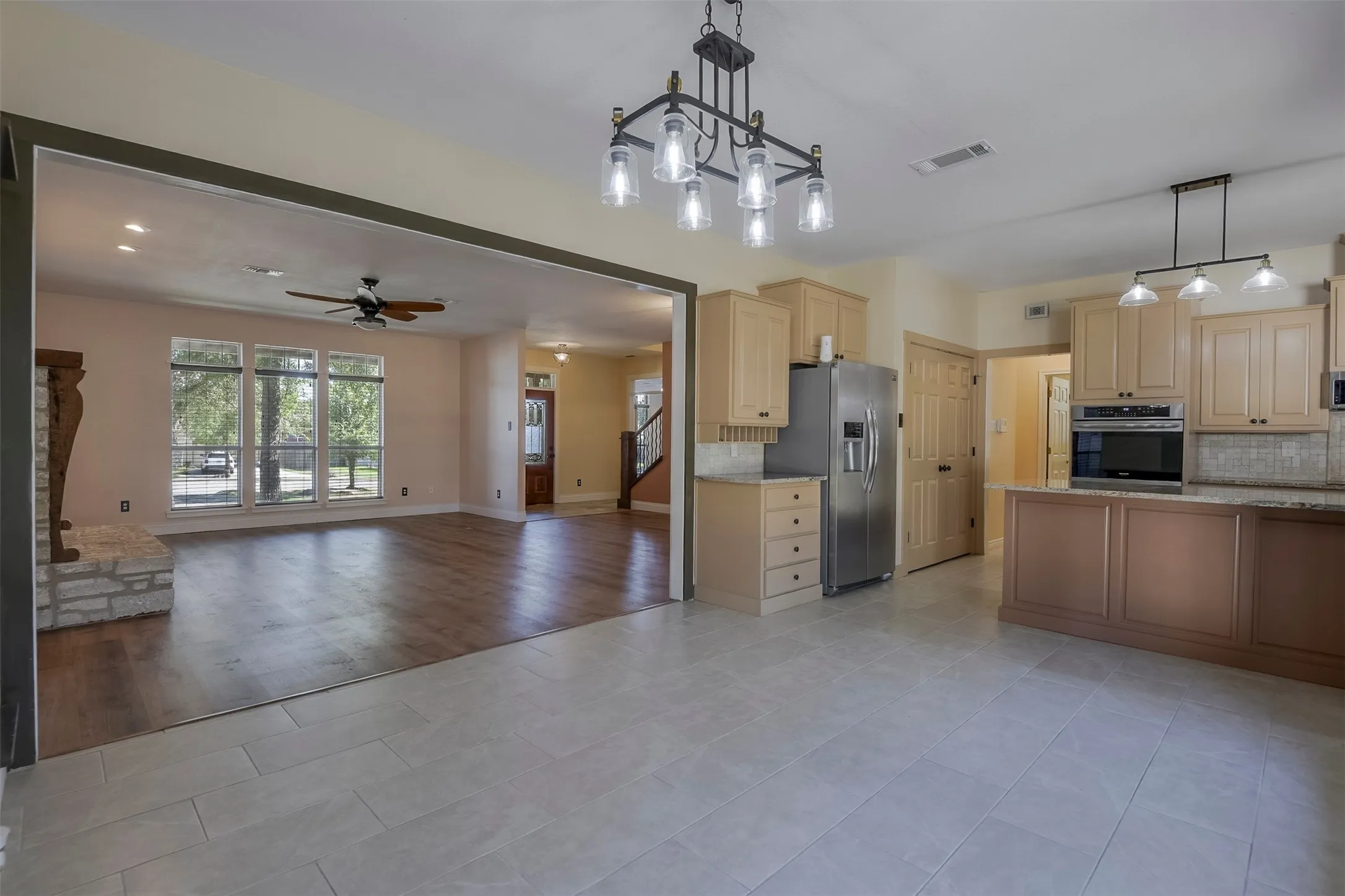 Spacious kitchen with light-toned cabinetry, stainless steel appliances, and an island with countertop