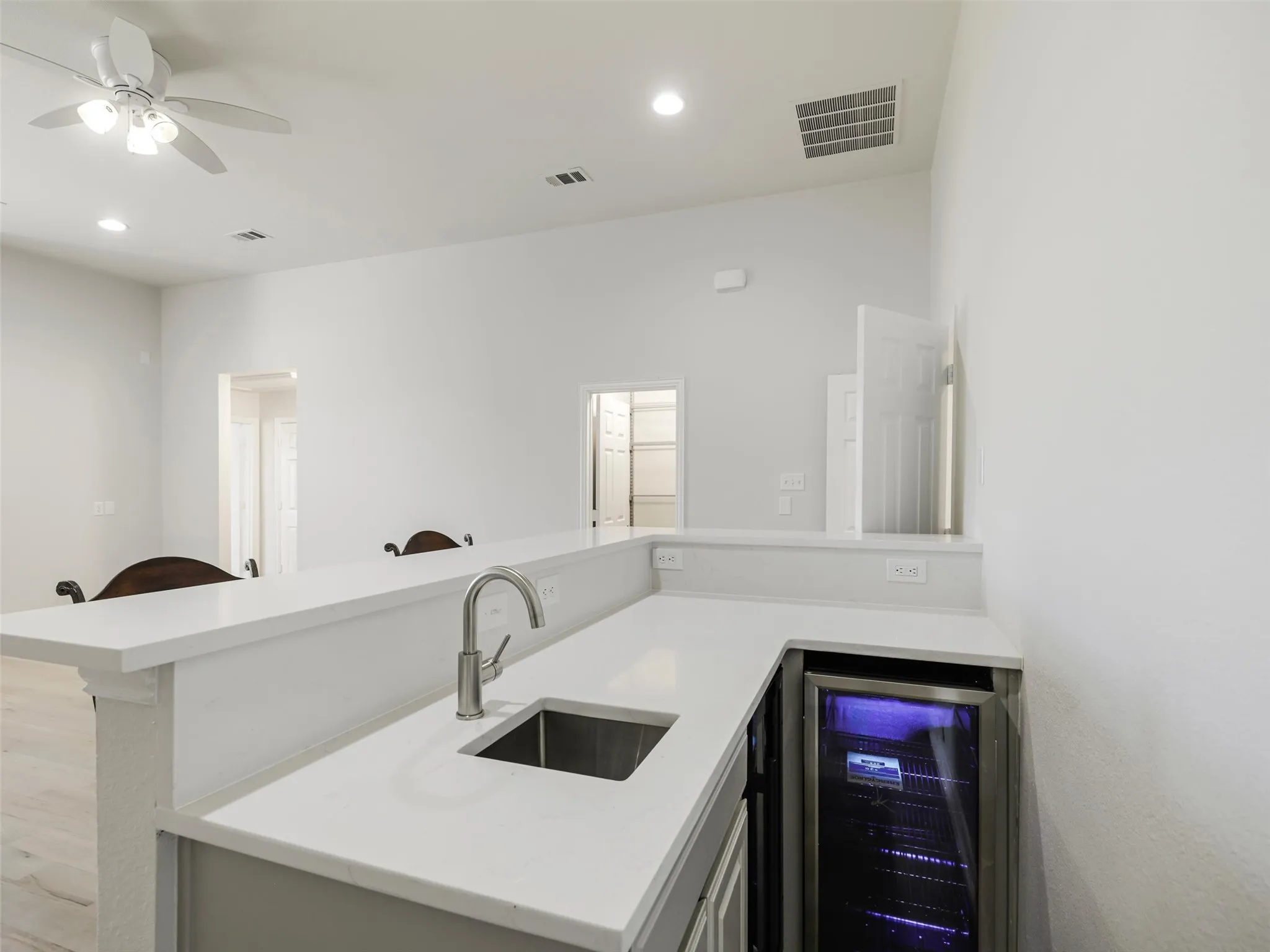 wet bar in game room with small refrigerator and wine cooler