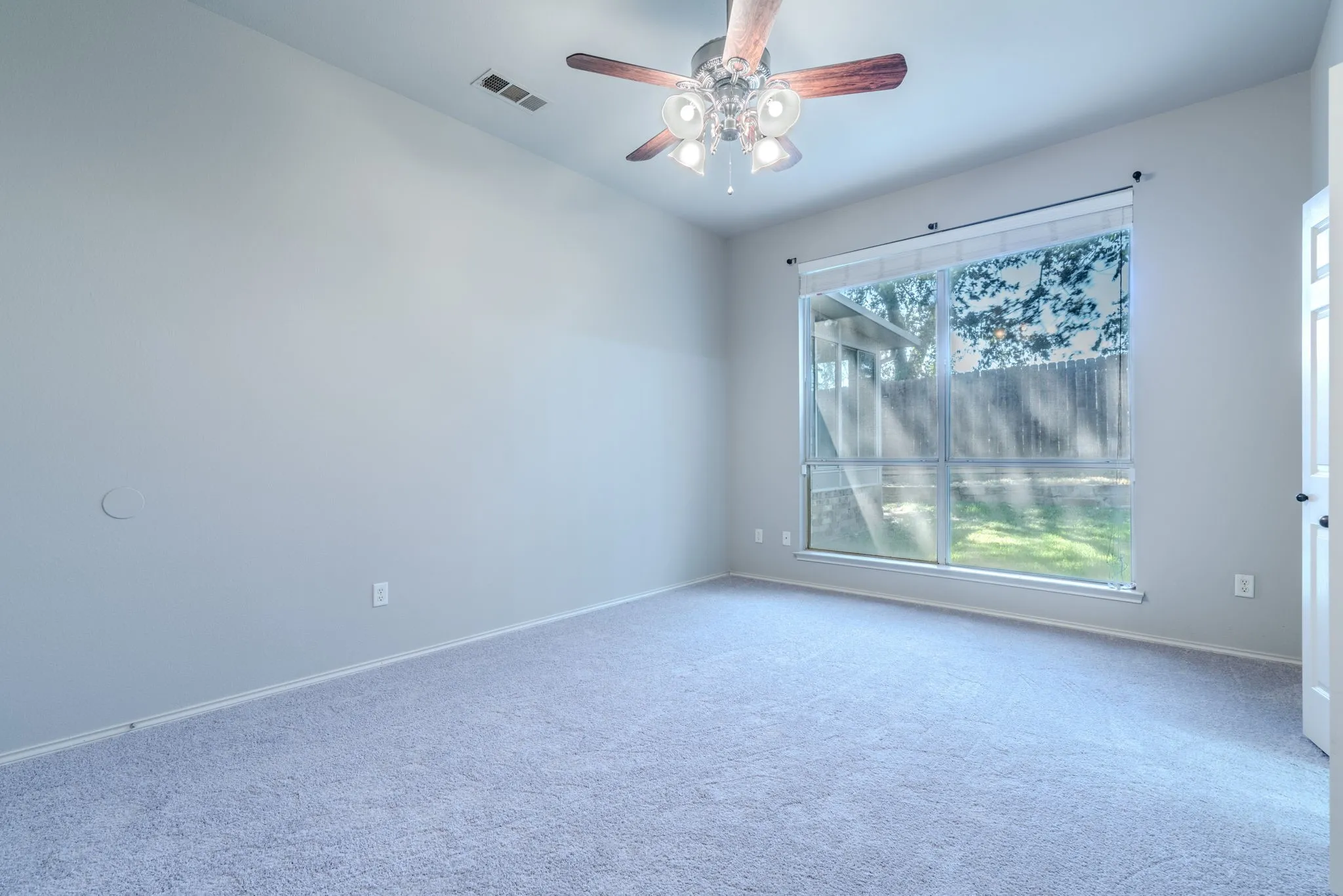 Large windows offer a view of the back yard from the primary suite