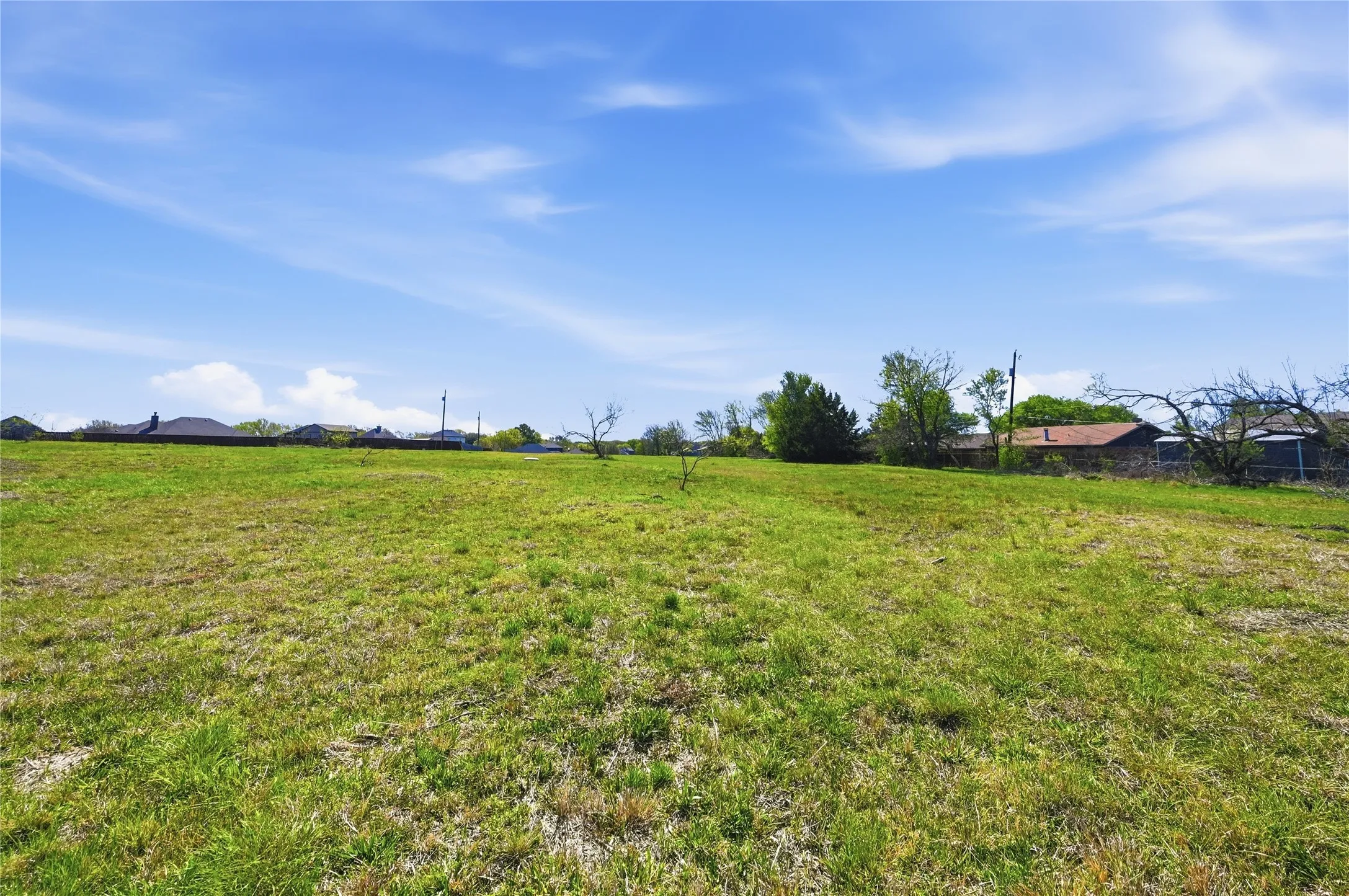 Expansive green space with distant residential structures