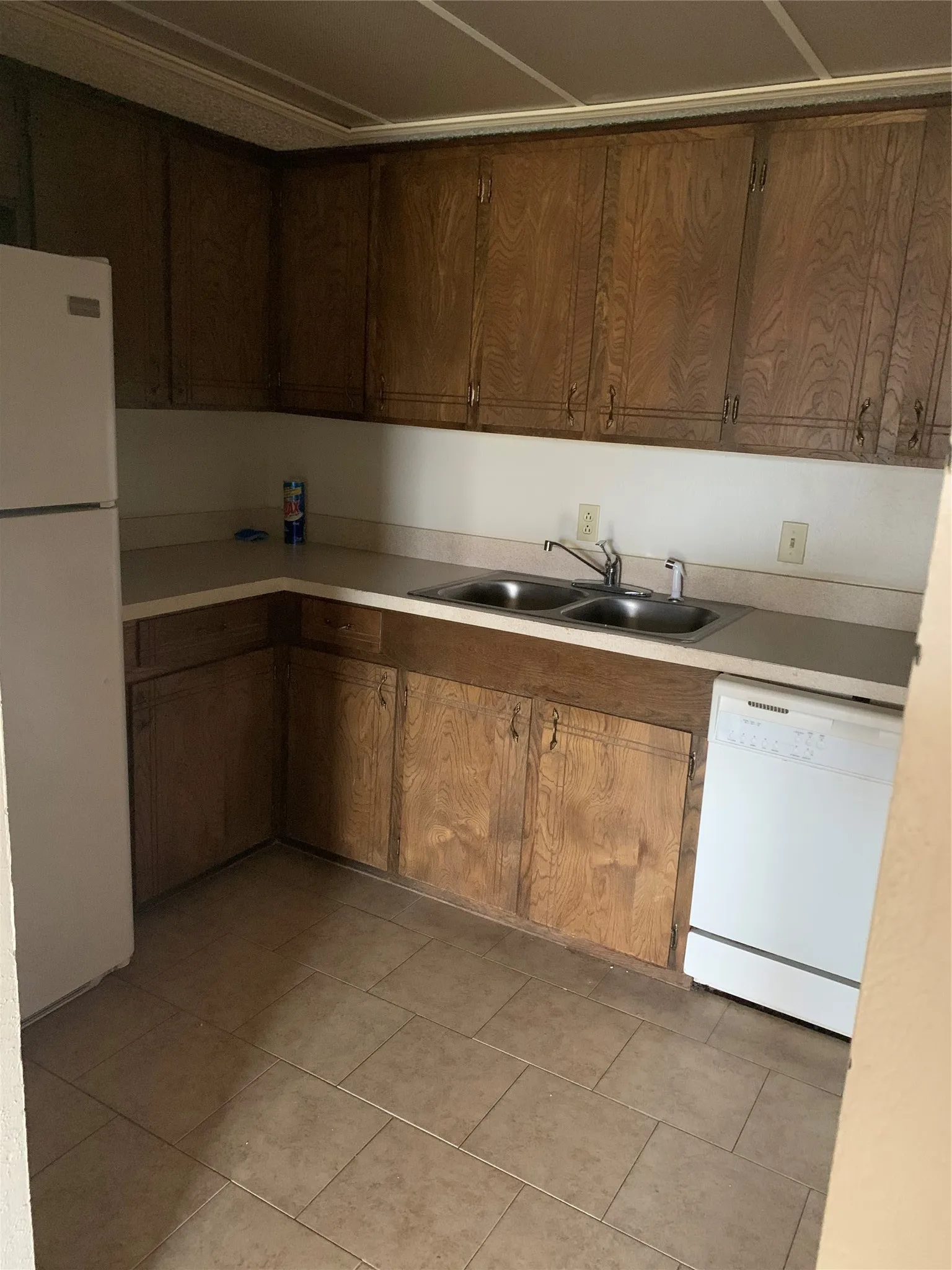 Kitchen featuring wood cabinetry, laminate countertops, and tile flooring