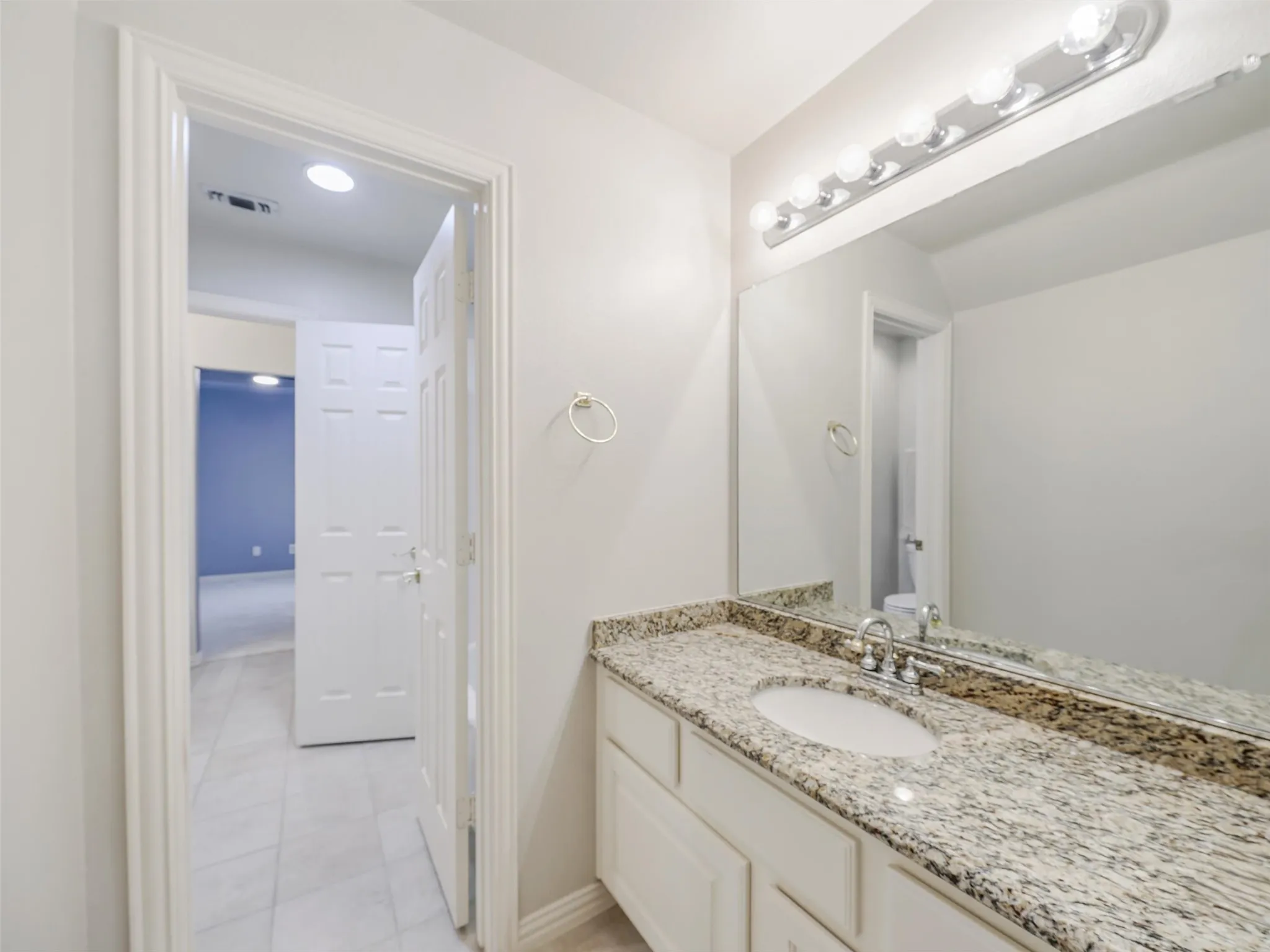 Vanity with granite countertop, integrated sink, and chrome faucet