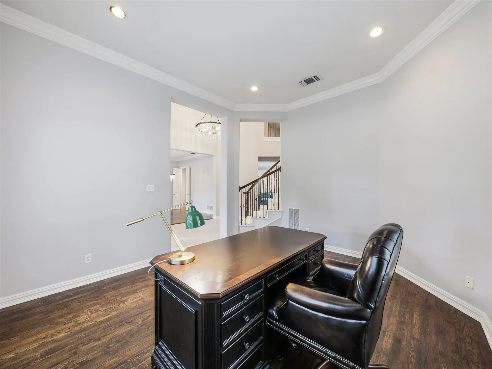 Recessed lighting, crown molding, wood-finish flooring, and a curved staircase with metal balusters